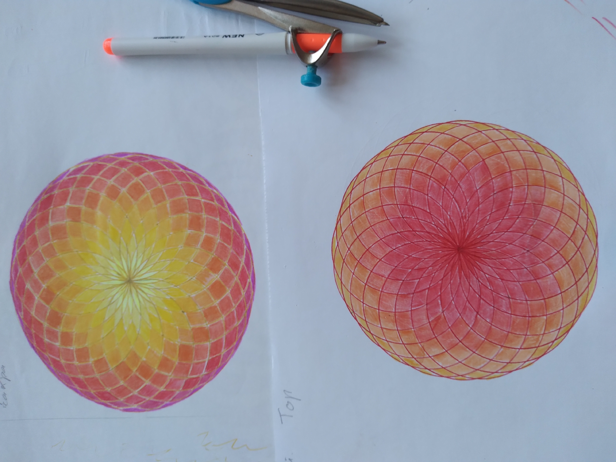 The image displays two colorful geometric drawings on white paper, reminiscent of mandalas or geodesic domes. The top drawing features a gradient of yellow to orange and pink hues, while the bottom drawing transitions from orange to red. Both are meticulously constructed with intricate lines forming repeating patterns. To the right of the drawings, a white pen with a neon orange cap and a silver compass with a blue accent are positioned, suggesting a creative or artistic process. The word "Top" is faintly visible on the paper below the upper drawing. The background is a plain white surface, likely a table or desk. There is no discernible information in the image that relates to the city of Baki, Uzbekistan.