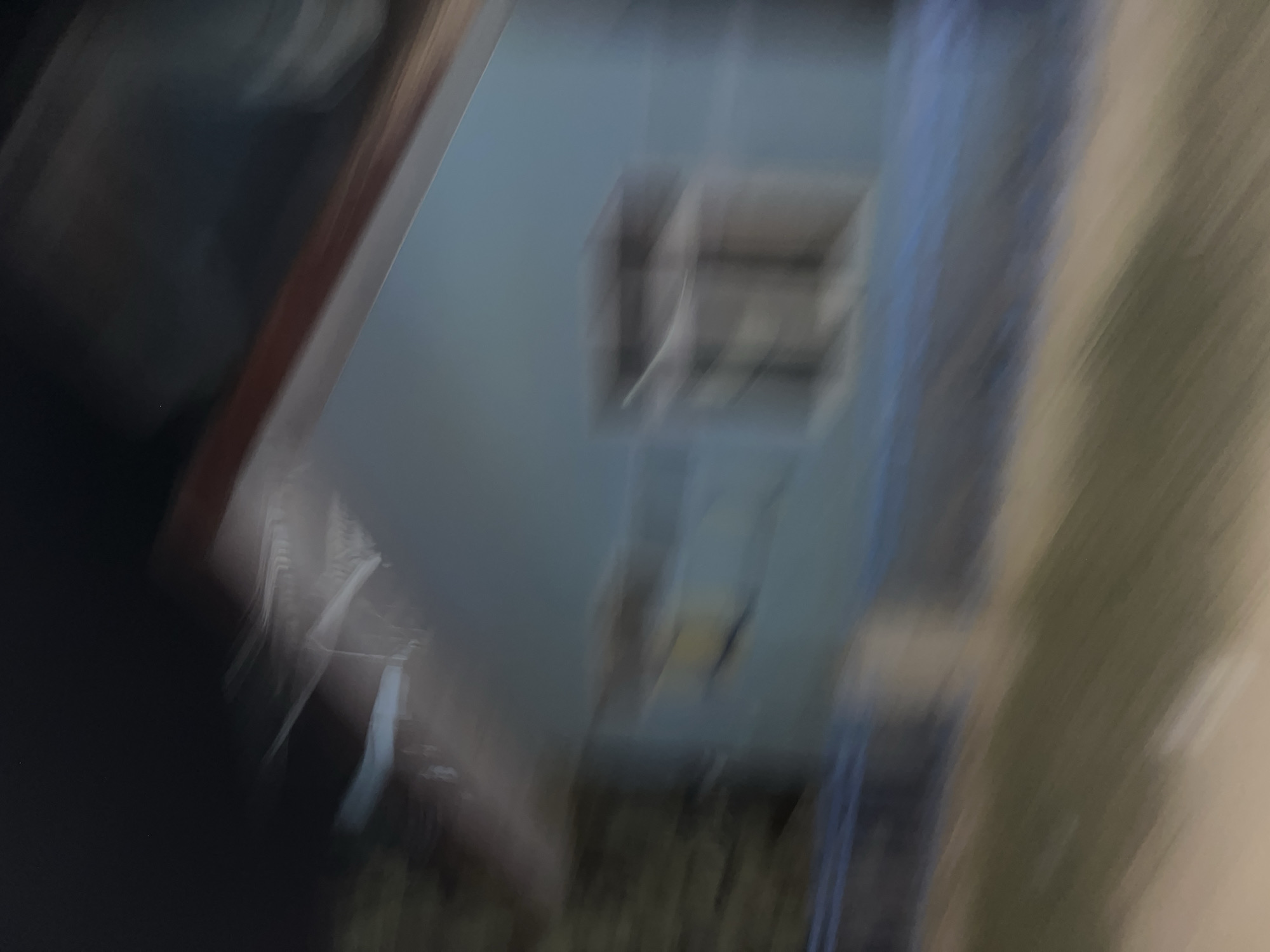 This media file depicts a blurred, abstract scene that appears to be an interior view looking out. The primary subject is a light-colored wall with a rectangular opening that hints at a window or doorway, suggesting an architectural element. The overall impression is one of movement and a lack of clear focus, making it difficult to identify specific objects or activities. The colors are muted, with shades of gray, blue, and brown dominating the image.
The setting seems to be indoors, possibly a room or hallway, with the opening leading to an exterior or another part of the building. There are hints of vertical lines and shapes, but they are too indistinct to be definitively identified. The lighting is soft and diffused, with no strong shadows to indicate a particular time of day or specific light source. The motion blur suggests that the image was taken while the camera was in motion, or that there was significant movement within the scene.
There are no discernible people or animals in the frame. The abstract nature of the image prevents any interpretation of an activity or event. No text is visible. Given the provided location context of Kesehatanbandar, Indonesia, this image could potentially be a glimpse into a building within that region, but the lack of detail makes it impossible to confirm. The overall mood is ambiguous due to the blurriness, neither explicitly positive nor negative.