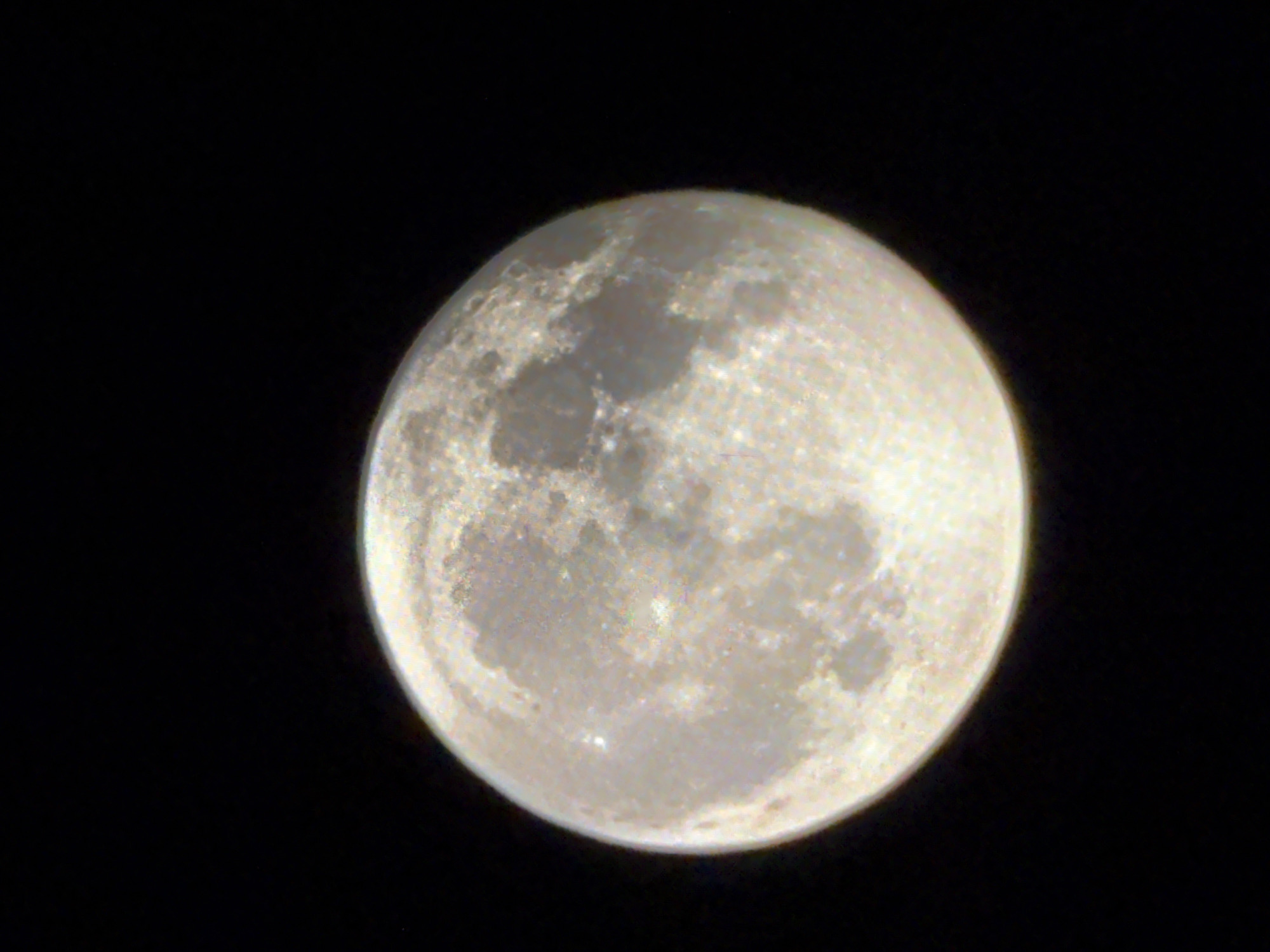 A full moon is visible against a black background. The moon is mostly round and appears textured with various craters and darker patches. There is no discernible location in the city of Bruck an der Mur, Austria, as the image only shows the moon in space.