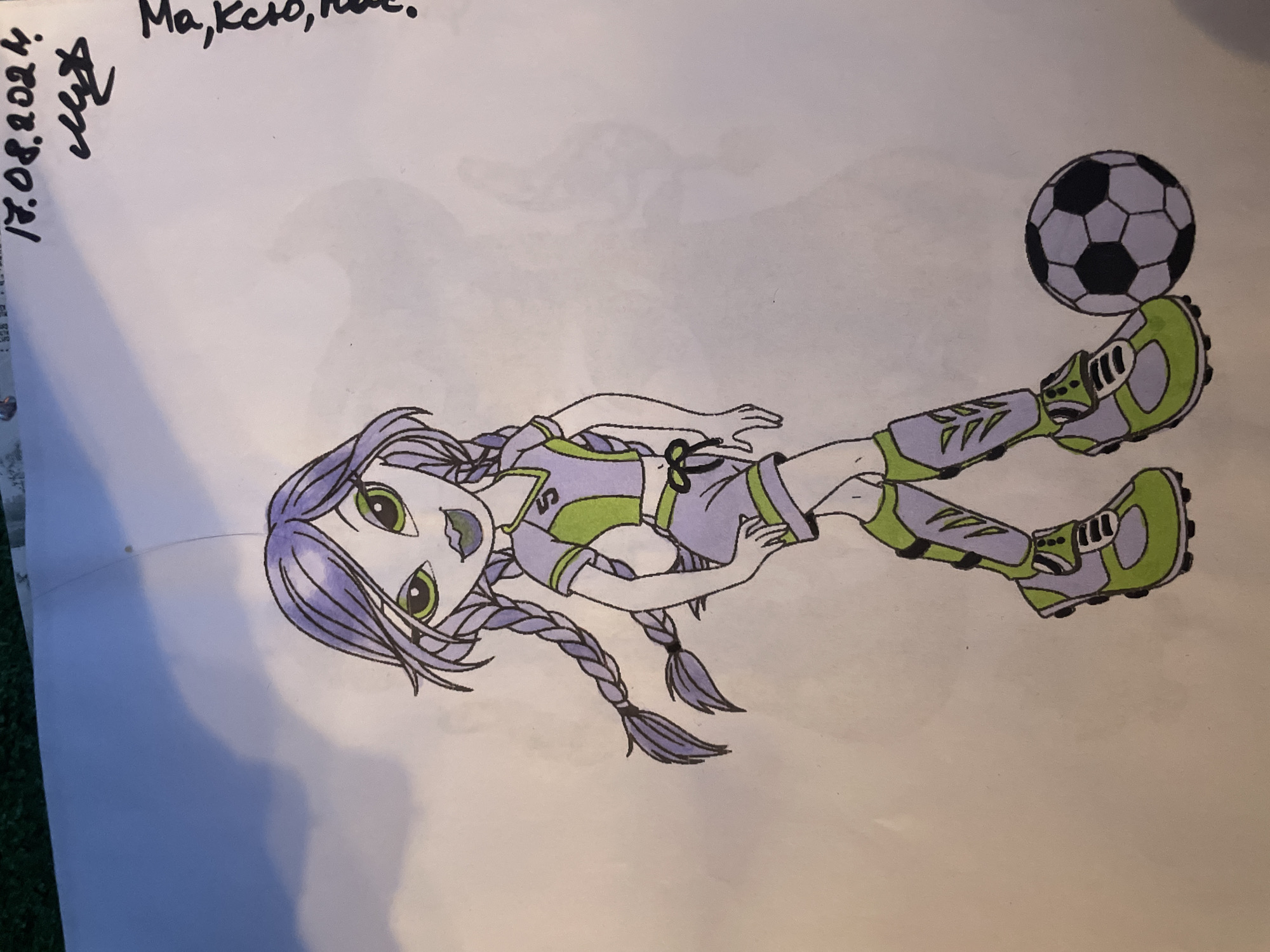 A drawing of a cartoon girl in a soccer uniform stands with a soccer ball. The girl has purple hair in braids, green eyes, and is wearing a purple and lime green soccer outfit with matching cleats. The drawing is on a piece of paper. In the upper right corner, there is handwritten text in black ink. The text appears to be a date and a signature. There are faint shadows of clouds in the background. This image was found in Saint Petersburg, Russia.