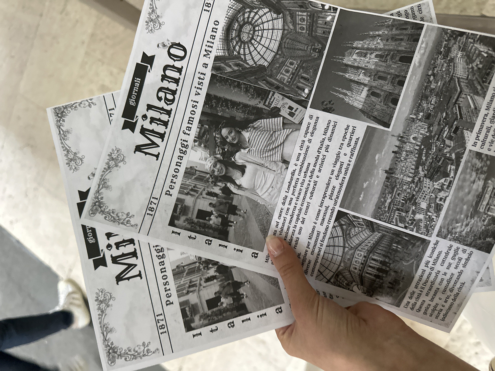 The image shows three newspaper-style leaflets in a person's hand, all promoting Milan, Italy. The leaflets feature the title "Milano" prominently, with the subtitle "Personaggi famosi visti a Milano" (Famous people seen in Milan). The leaflets include photos of the Galleria Vittorio Emanuele II, the Duomo di Milano, and an overall cityscape. There are also photographs of people visiting the city. The text on the leaflets describes Milan as a city of elegance, fashion, and culture. The leaflets are black and white and feature ornate floral borders. The date "1871" is also printed on the leaflets.