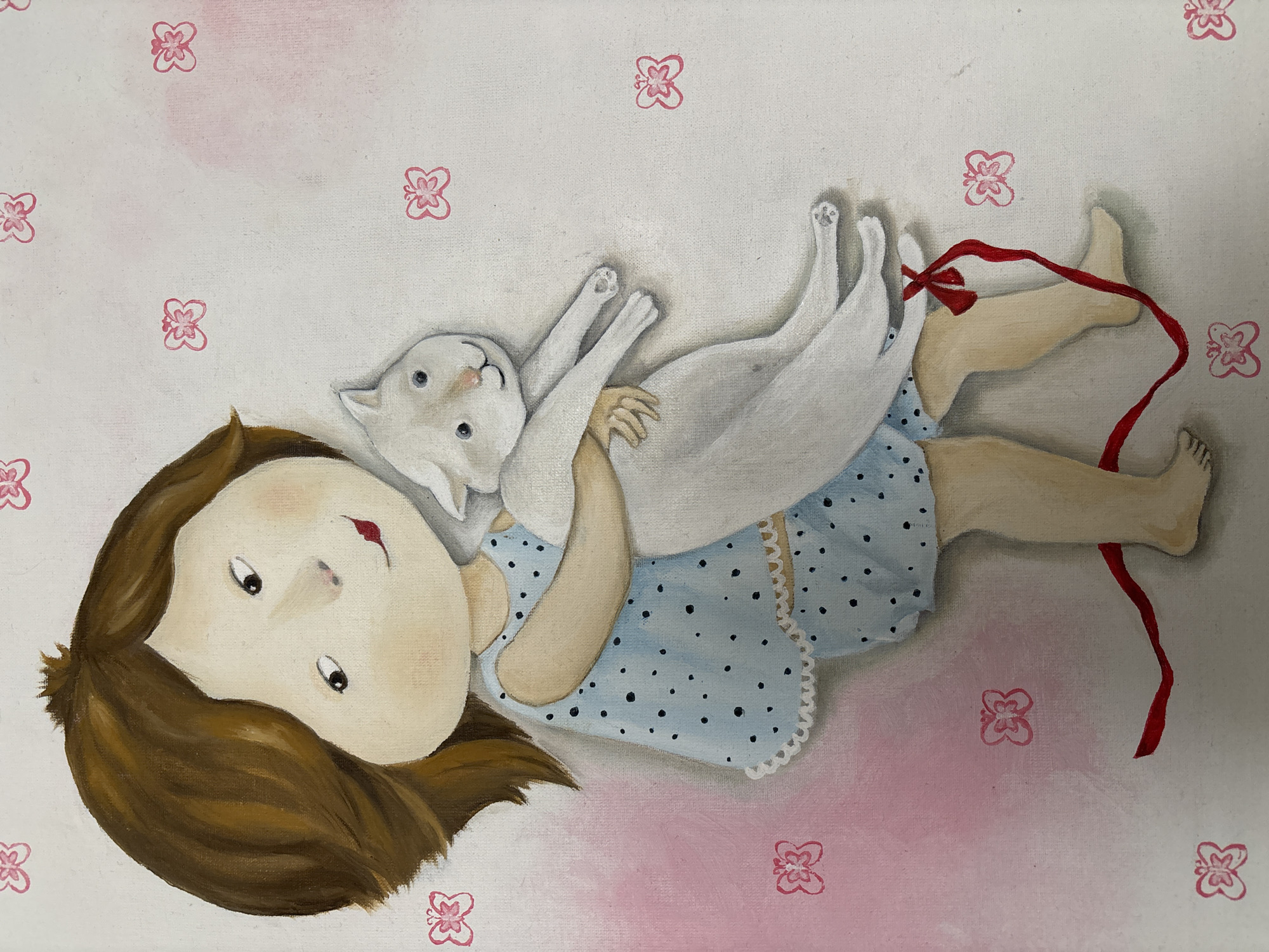 This is a painting of a young child, possibly a girl, with brown hair and fair skin, holding a white cat. The child is wearing a light blue pajama set with dark blue polka dots and white trim. The cat is held in the child's arms, and a red ribbon is tied around the cat's waist and trails down to the child's legs, which are bare. The background is a pale, textured surface with faint pink washes and small, pink butterfly-like stamps or prints scattered across it. The style of the painting is illustrative and somewhat whimsical, with rounded features for the child and a simplified depiction of the cat. There are no discernible elements in the image that indicate a specific location in Shepetivka, Ukraine, or any other city.