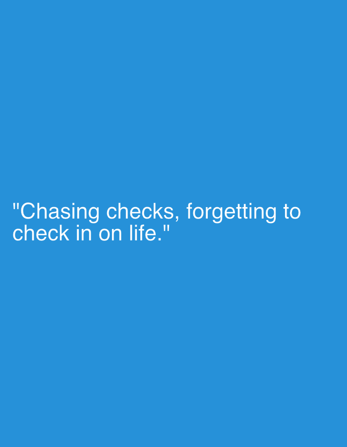 The image displays the text: "Chasing checks, forgetting to check in on life." The text is in white and appears to be centered on a solid blue background. No people, subjects, objects, actions, interactions, or environmental details are visible other than the text and background.