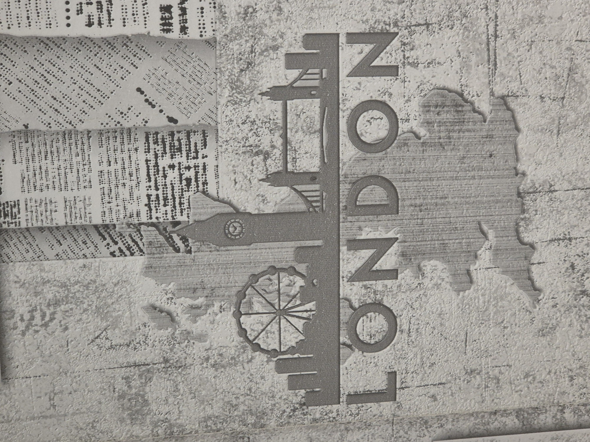 The image displays a textured wallpaper design with a grey and white palette. The design features a silhouette of London landmarks, including the London Eye, Big Ben, and Tower Bridge. The word "LONDON" is prominently displayed in large, embossed capital letters below the silhouette. The background of the wallpaper is designed to resemble torn pieces of newspaper with text and dot patterns, overlaid on a textured, distressed surface that mimics concrete or stone. There are no people or discernible actions taking place. The image does not depict any scenes or elements related to the city of Новоишимское, Kazakhstan.