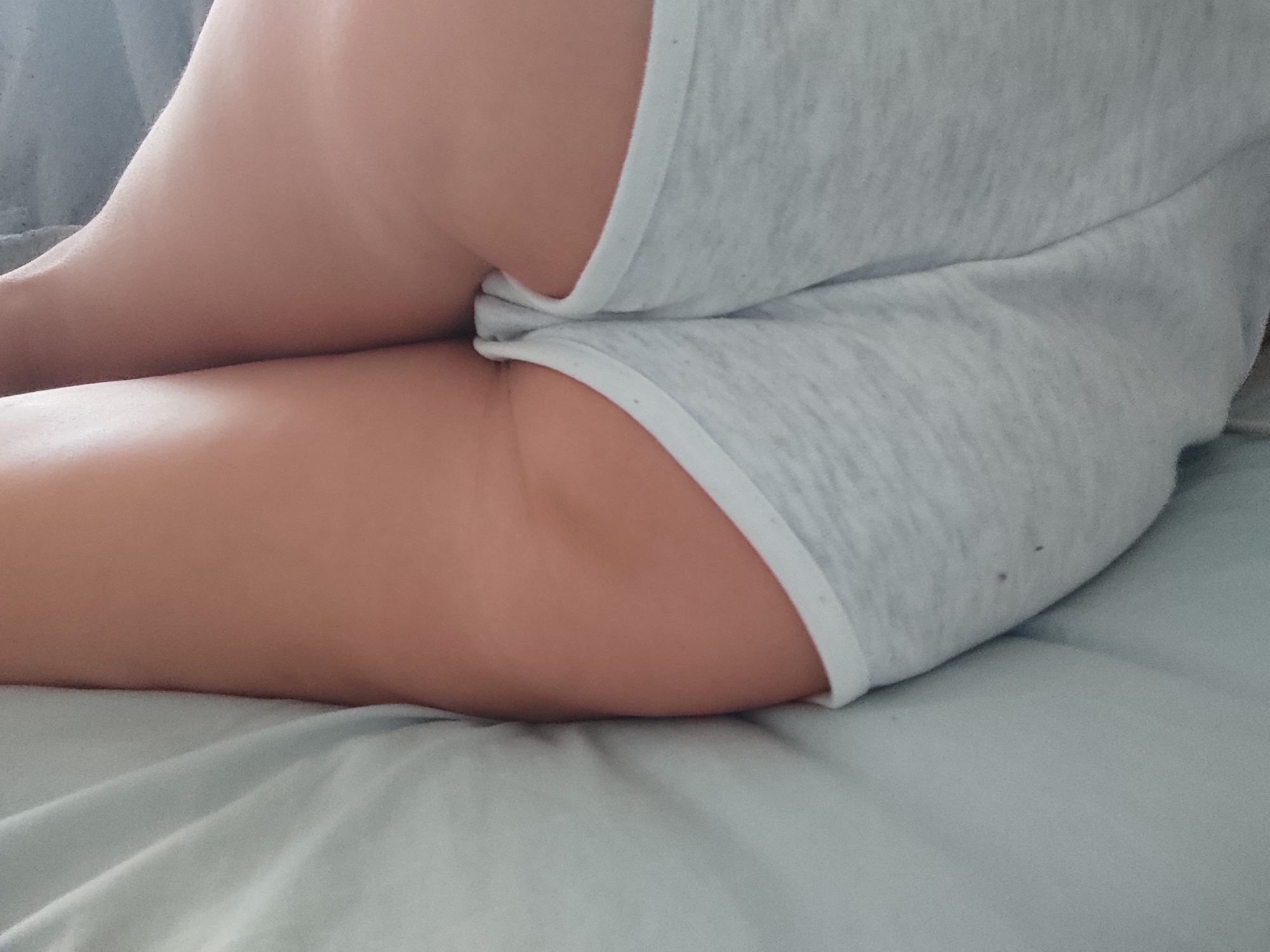 The image shows a close-up view of a person's thigh and buttocks, wearing light gray underwear. The person is lying on a light blue sheet. The lighting suggests an indoor environment, possibly a bedroom. There is no indication of the specific location within Blanes, Spain.