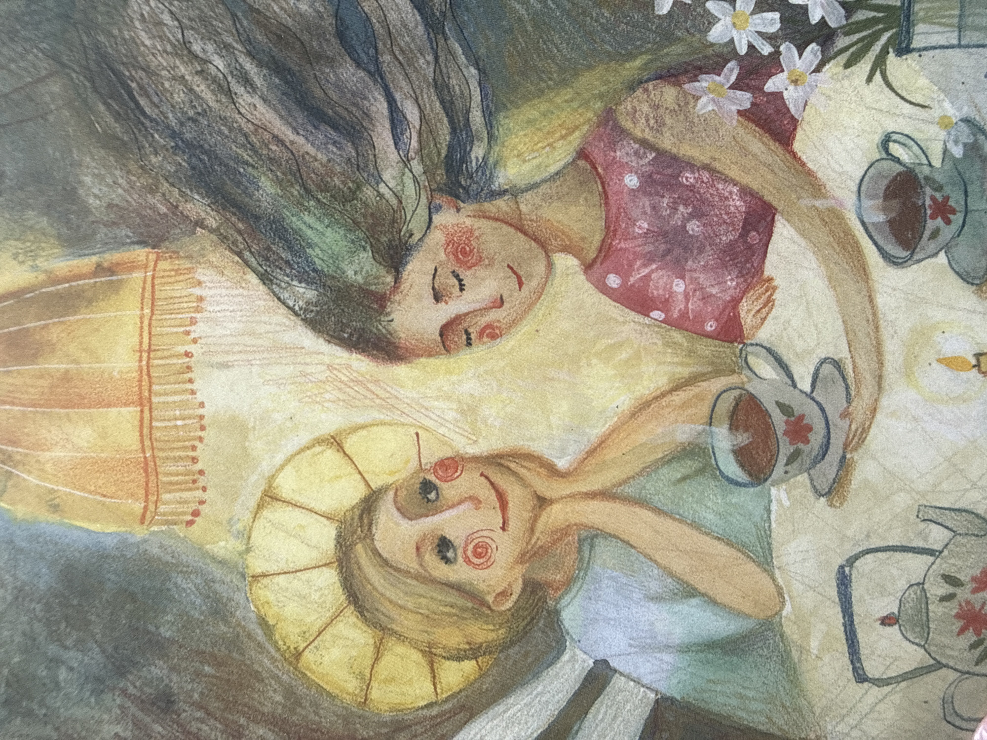 The image is a watercolor painting depicting two people sitting at a table with teacups and teapots, suggesting a tea party. One person, with long, dark, wavy hair and a pink polka-dot dress, is leaning back with their eyes closed and a gentle smile, holding a teacup. The other person, with shorter blonde hair styled in a halo-like fashion and wearing a blue shirt and striped garment, is looking forward with a wide smile, also holding a teacup. Both figures have exaggerated facial features, with rosy cheeks and circular designs on their eyes, giving them a whimsical appearance.
The scene is set at a table adorned with a floral tablecloth. Several teacups and two teapots are visible, one of which appears to be pouring tea. Small white flowers with yellow centers are scattered around the table, adding to the decorative and playful atmosphere. A yellow cylindrical object with orange stripes and a red dotted edge is present on the left side of the frame, possibly a lampshade or a decorative element. The lighting in the painting is warm and soft, with a faint glow from what might be a candle or a lamp, hinting at a cozy or perhaps evening setting. The overall mood is cheerful and relaxed, conveyed through the smiling faces and the pleasant depiction of a shared activity. There is no visible text in the image. The style of the illustration is reminiscent of children's book art, with its simplified forms and vibrant, yet soft, color palette.