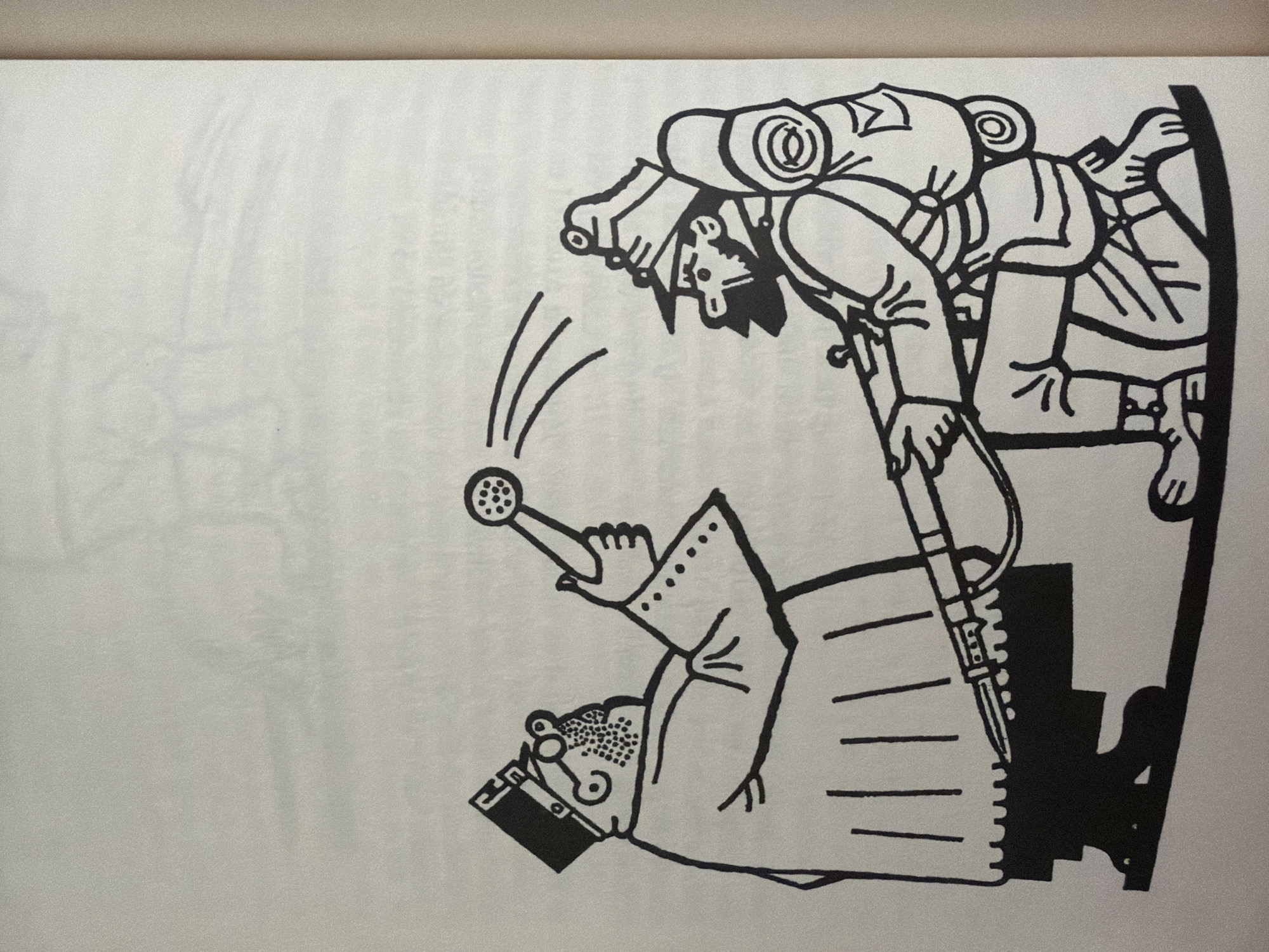 The image depicts a black and white illustration of two figures. On the left is a person dressed in a formal robe and a cap, holding a shower head from which arcs are emanating, suggesting water is being sprayed. This figure has glasses and a beard. On the right is a person in military attire, including a helmet and a backpack, kneeling and holding a rifle that is pointed towards the ground. The figures are positioned as if in an interaction, with the robed figure appearing to "shower" the kneeling soldier. The background is plain white, offering no environmental context or indication of a specific location within Pazardzhik, Bulgaria or elsewhere. The illustration style is simple and cartoonish, with bold black lines.