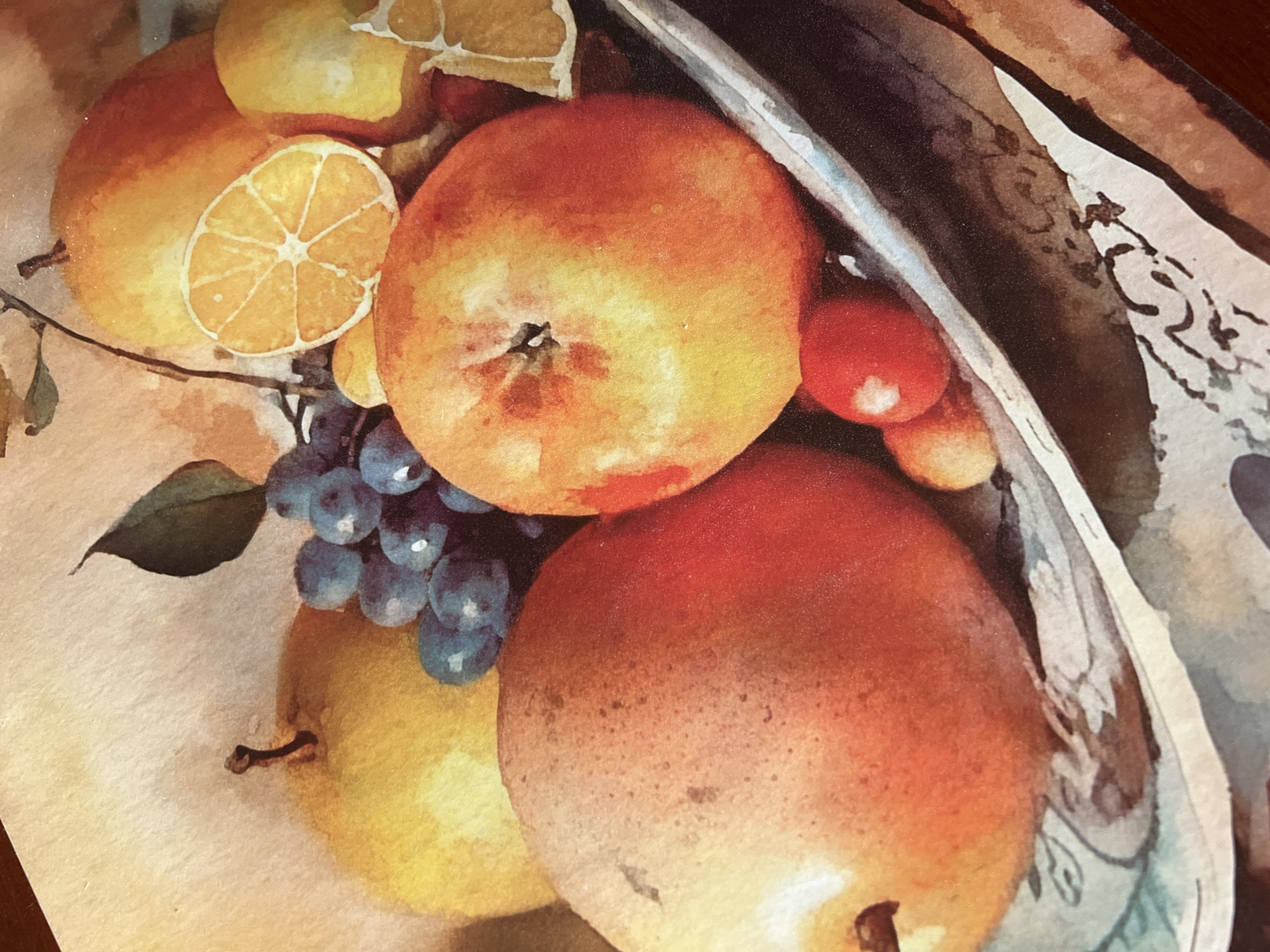 This is a close-up, overhead watercolor painting of a fruit still life. The arrangement includes a large, reddish-orange pear in the foreground, an apple with similar coloring behind it, a yellow pear or apple to the left, a cluster of blue grapes, and slices of orange. There are also a few small red berries. The fruits are placed in a light-colored, shallow dish with a decorative rim. The background is a soft, textured light brown. The painting style is impressionistic with visible brushstrokes and soft edges. There is no discernible location within the city of Minsk, Belarus, or any people or actions depicted.