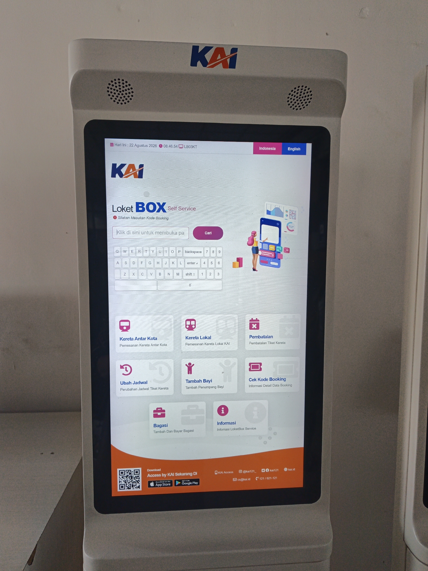 The image shows a self-service ticket kiosk for KAI (Kereta Api Indonesia) at Klaten Station, Indonesia. The kiosk has a large touchscreen display. The screen displays the current date and time as August 22, 2020, 08:46:54, and the station code LB03KT. The main interface allows users to book tickets by entering a booking code. A virtual keyboard is displayed on the screen. Below the booking code input, there are several options represented by icons: "Kereta Antar Kota" (Intercity Train), "Kereta Lokal" (Local Train), "Pembatalan" (Cancellation), "Ubah Jadwal" (Change Schedule), "Tambah Bayi" (Add Infant), "Cek Kode Booking" (Check Booking Code), "Bagasi" (Baggage), and "Informasi" (Information). The bottom of the screen includes a QR code for downloading the "Access by KAI" app, with links to the App Store and Google Play. Contact information for KAI Access, social media handles, and a phone number are also visible. The kiosk is white with KAI branding. The background is a plain, light-colored wall, consistent with an indoor public space like a train station.