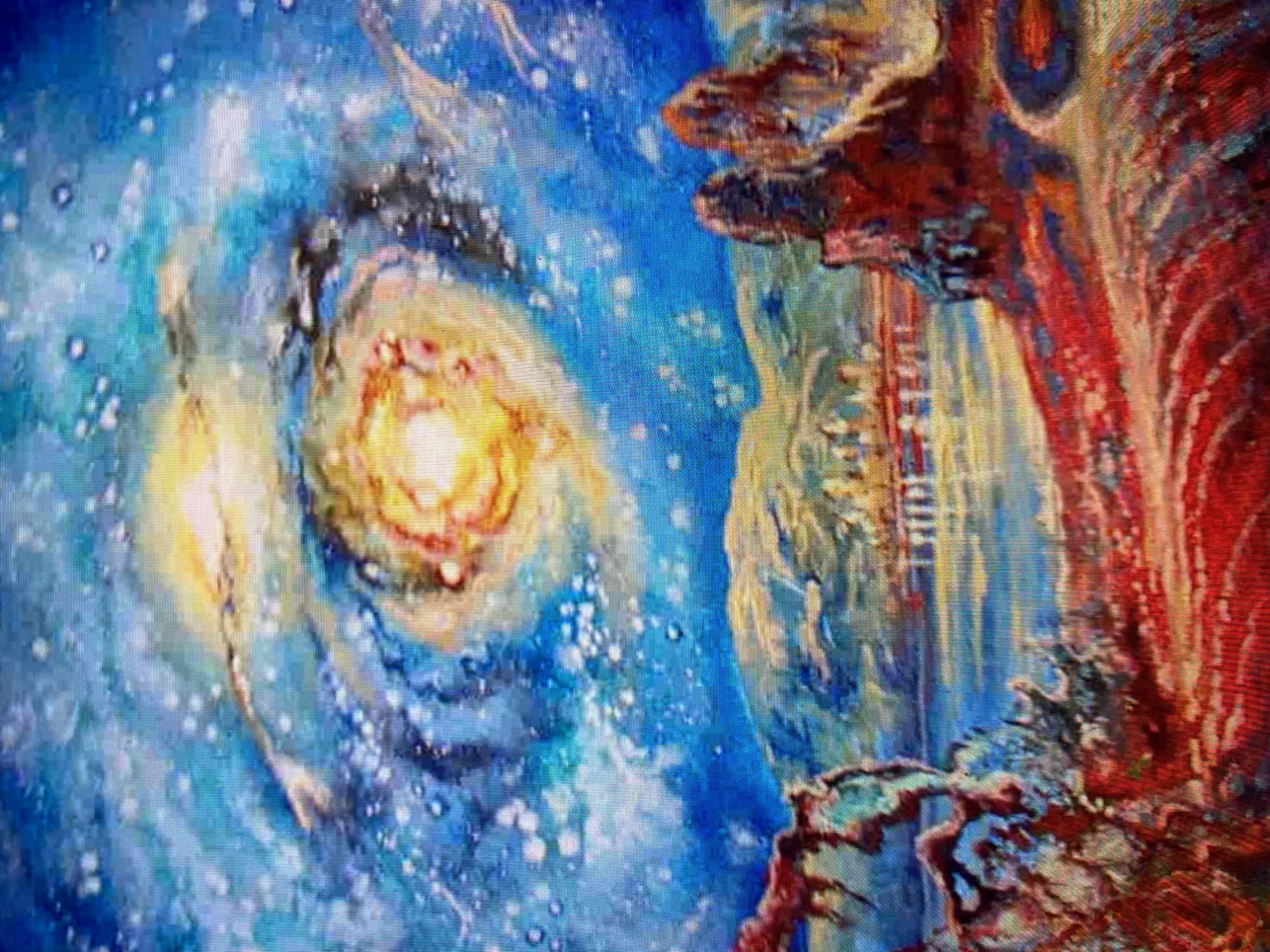 This is a painting of a surreal landscape under a swirling galaxy. In the foreground, there are red, rocky formations and a body of water reflecting the colorful sky. In the middle ground, there are rolling hills with hints of buildings that could suggest a city. The background is dominated by a vibrant, spiraling galaxy with bright stars. The overall scene is fantastical and dreamlike, with a strong emphasis on color and cosmic elements. The location is not identifiable within a known city.