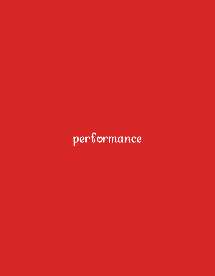 The image is a close-up, medium shot of the word "performance" written in white, stylized font on a solid red background. The 'o' in "performance" is replaced with a small heart symbol. The text is centered horizontally and located in the lower half of the frame. The background is a uniform, vibrant red. There are no other objects, people, or discernible environmental details.