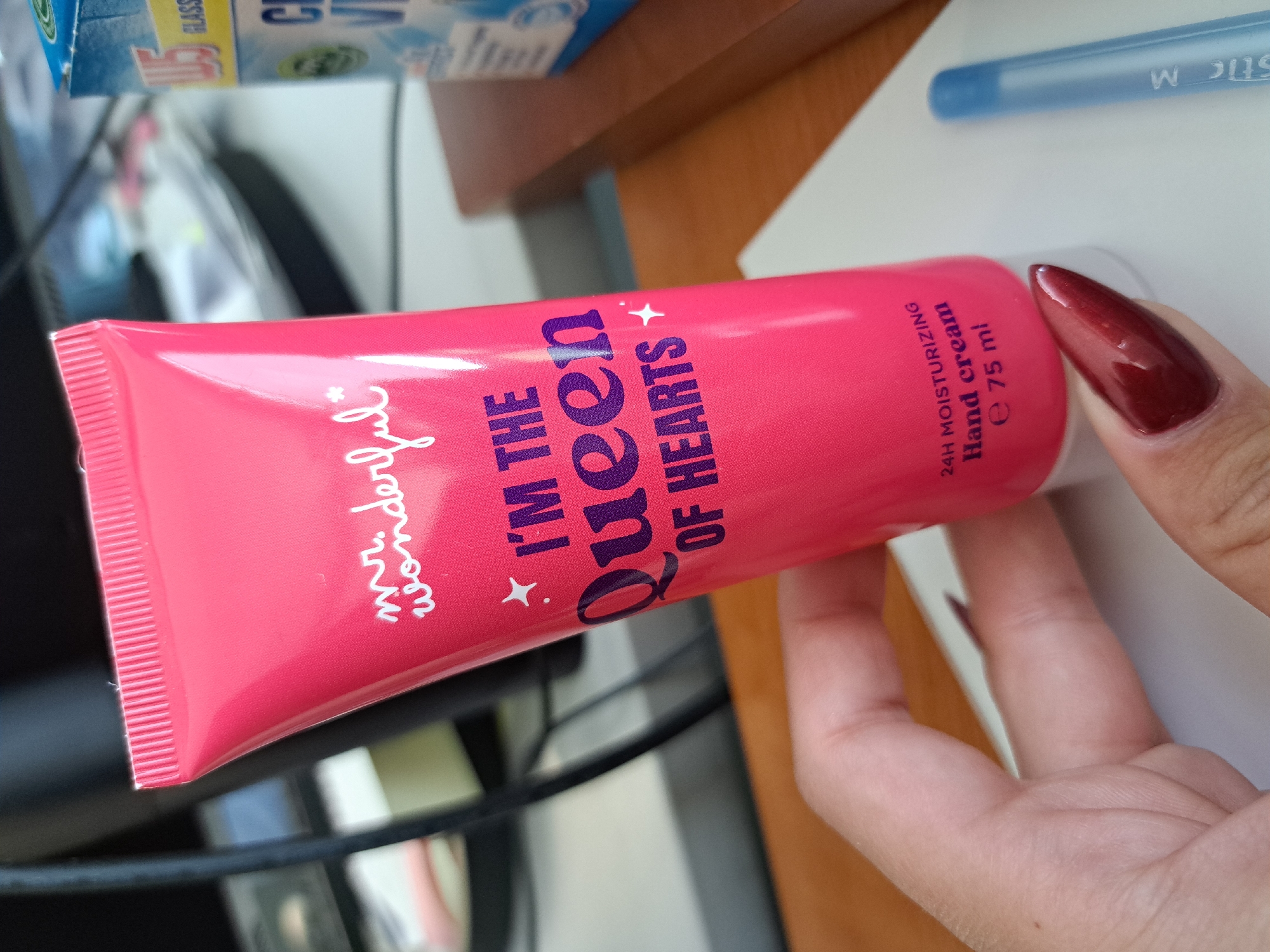 A person is holding a pink tube of "Mr. Wonderful" hand cream that says "I'M THE QUEEN OF HEARTS" on it. The tube also indicates that it is 24H moisturizing hand cream and contains e 75 ml. A blue pen is visible in the background. The specific location of the city of Sofia, Bulgaria is not discernible from the image.