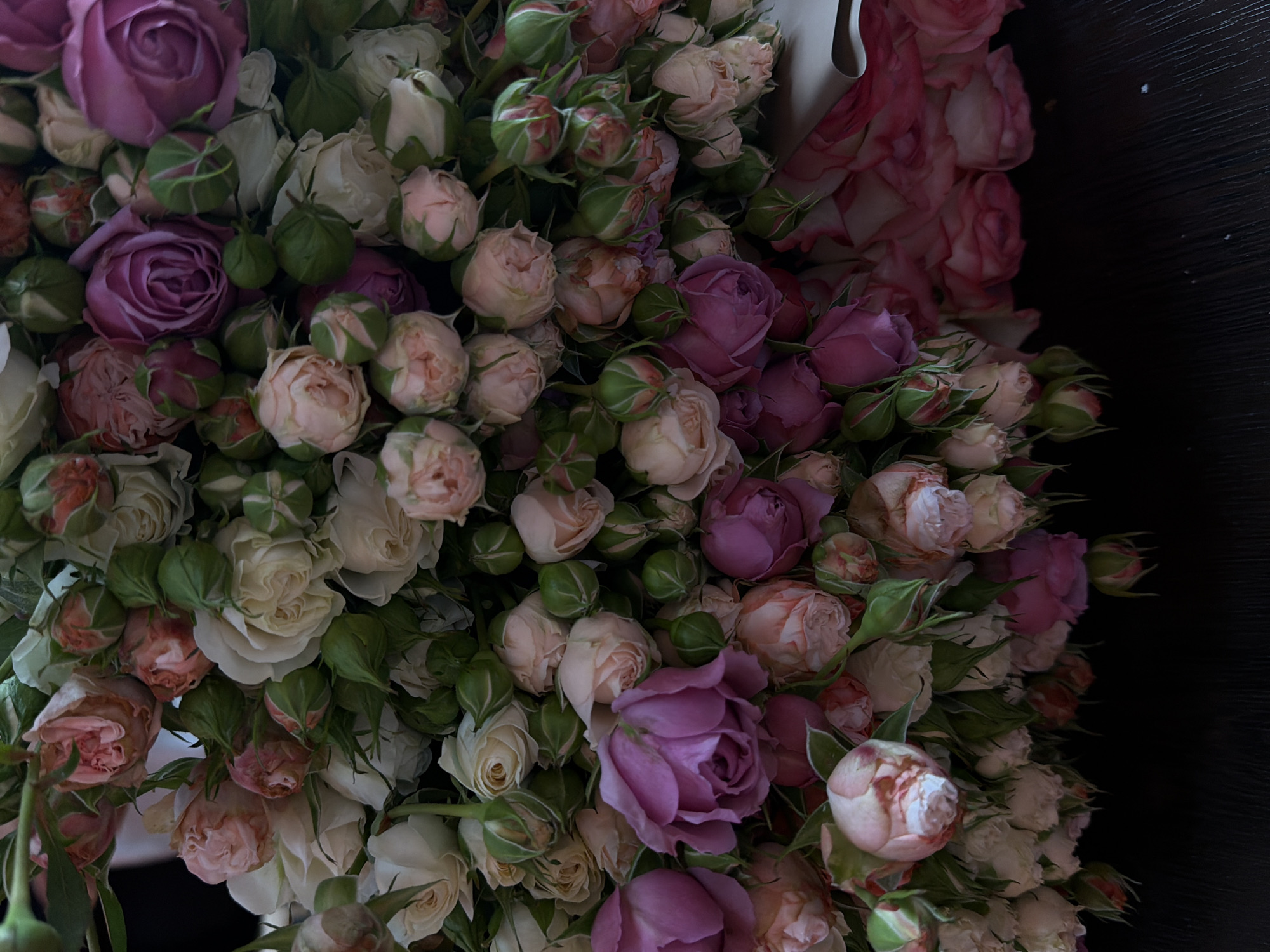 The image shows a close-up of a lush bouquet of roses in various shades of pink, white, and lavender. Some roses are fully open while others are still buds. The background is dark. The location and information about Yerevan, Armenia cannot be determined from the image.