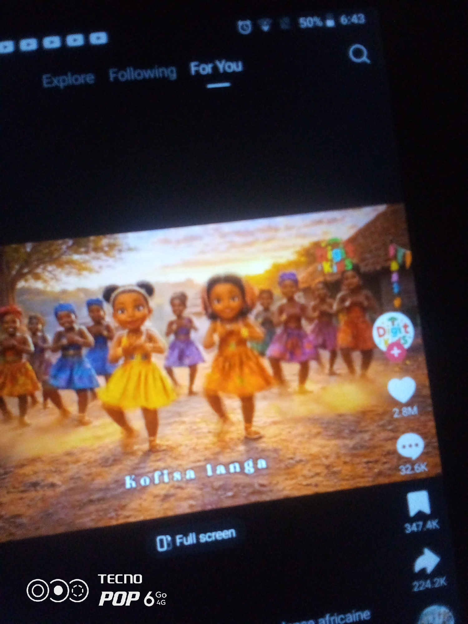 The image shows a screen displaying a video. At the top of the screen, there is a status bar with a battery icon showing 50% charge, the time "6:43", and a search icon. Below the status bar, there are navigation tabs labeled "Explore", "Following", and "For You", with "For You" underlined. The main content of the screen is a video featuring a group of animated young girls in colorful traditional attire dancing in an outdoor setting. The girls are positioned on a dirt path with a backdrop of trees and thatched-roof huts. Some of the girls are wearing yellow, blue, or purple dresses. Text overlays are visible on the video: "Kofisa langa" in white font, and a circular logo with text that appears to read "Dit Kids". On the right side of the screen, there are social media interaction icons: a white heart with "2.8M" next to it, a speech bubble with "32.6K", a bookmark icon with "347.4K", and a share arrow with "224.2K". At the bottom of the screen, the text "Full screen" is displayed, along with a TECNO POP 6 4G logo. The image is likely a screenshot of a video being watched on a mobile device. There is no information within the image that indicates the location is Howayi, Nigeria.