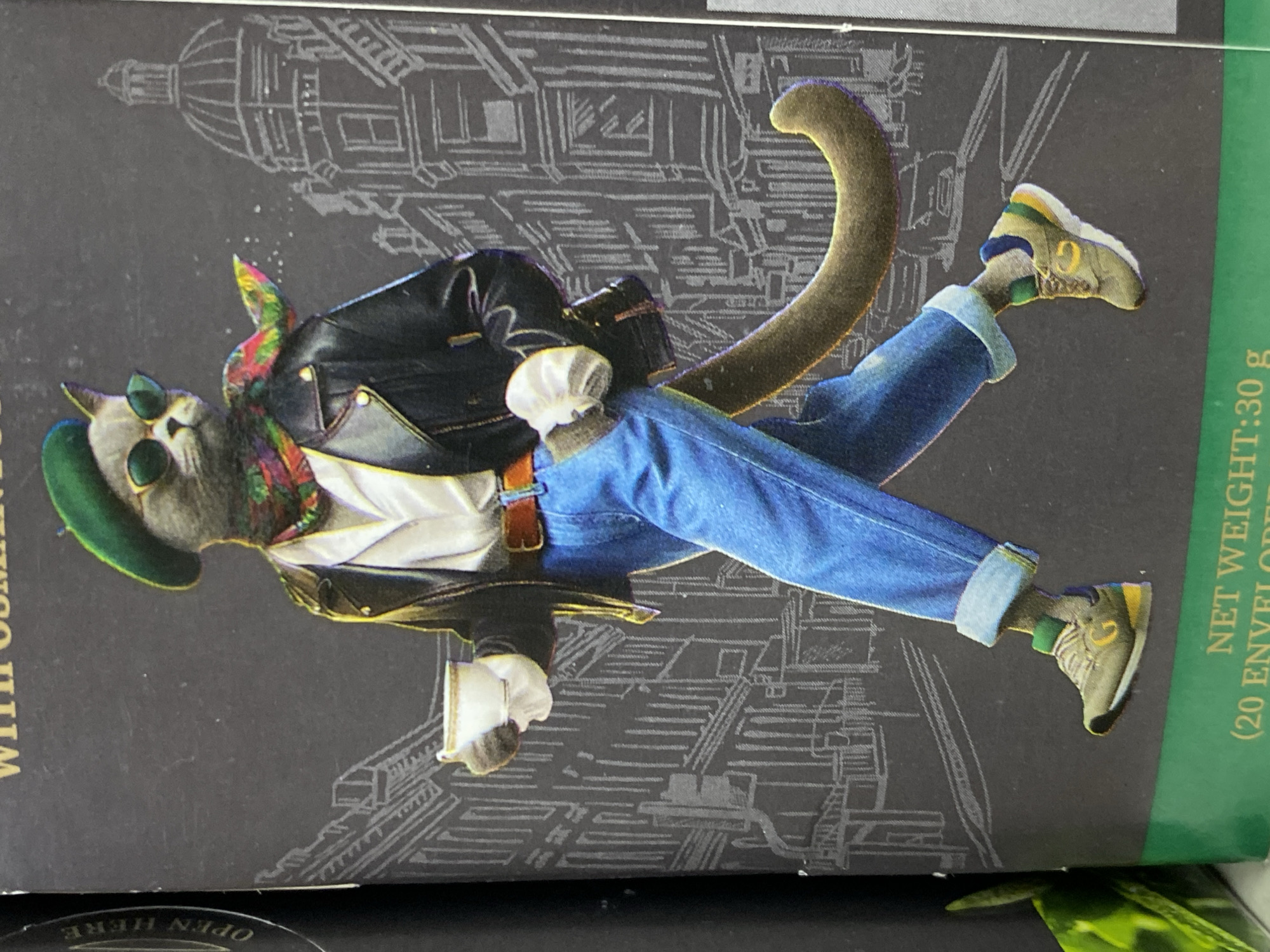 A box, possibly a product container, features an illustration of an anthropomorphic cat dressed in contemporary clothing. The cat wears sunglasses, a green beret, a patterned scarf, a black leather jacket over a white shirt, blue jeans with rolled-up cuffs, and sneakers. The cat also has a brown tail. The background of the illustration depicts an architectural drawing of a building, possibly located in a city. Text on the box includes "NET WEIGHT: 30 g (20 ENVELOPES)." Another text is "WITH OSMAN", and "OPEN HERE" is written on the bottom left corner of the box.