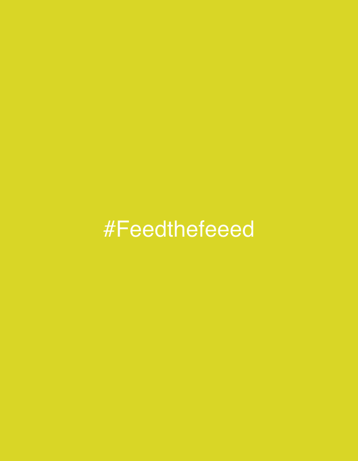 The image displays a solid, monochromatic yellow background. Centered horizontally within the frame, and slightly above the vertical midpoint, is the white text "#Feedthefeeeed". No people, subjects, objects, actions, interactions, or discernible environmental elements are visible within the image. The content provides no visual cues to indicate a specific geographical location, including the city of Kazan, Russia.
