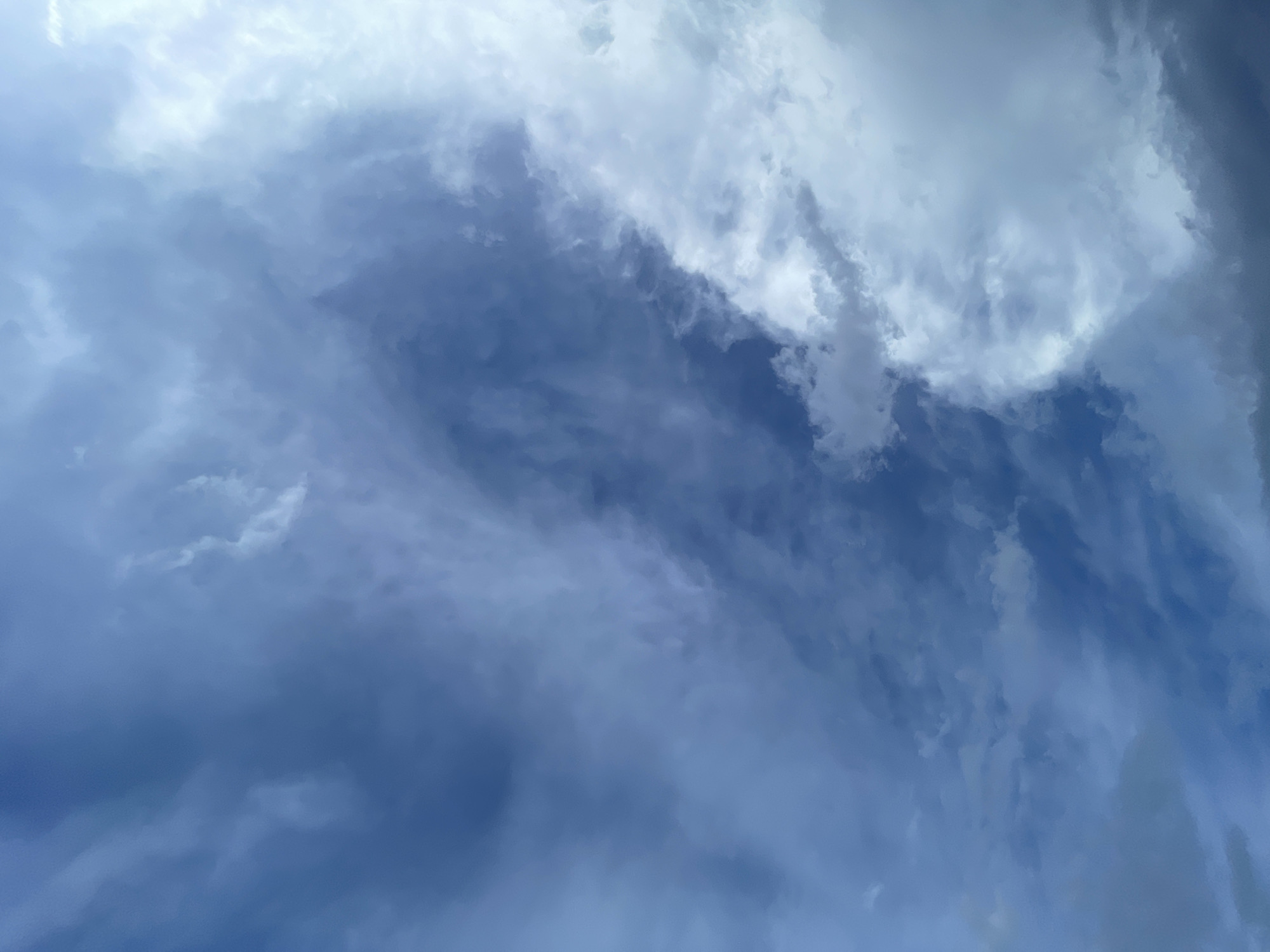 The media file presents an expansive view of the sky, dominated by various cloud formations over Barakin Akawo, Nigeria. The scene is a tapestry of blues and whites, with a spectrum of cloud densities and textures. Lighter, wispy cirrus-like clouds are visible, appearing streaky and translucent, blending into broader, more opaque white and grey cloud masses. Deeper shades of blue sky are visible between the clouds, especially towards the bottom and right side of the main image, indicating partially clear conditions. The clouds appear to be in motion, forming dynamic patterns that stretch and swirl across the frame.
The overall impression is that of a daytime sky, though the specific time of day is not discernible from the lighting, which ranges from bright whites on the cloud edges to soft blues and deeper greys within the cloud bodies. There are no visible people, objects, or text. The weather appears to be partly cloudy, with a calm atmosphere highlighting the natural beauty and vastness of the sky. The crops help to emphasize the intricate details and varying forms within the cloud structures, from soft diffused areas to more defined edges.