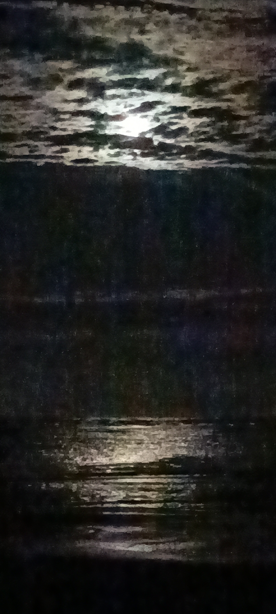 The image is a vertical, abstract, oil-on-canvas style depiction of a moonlit scene over water. The sky is filled with textured, dark clouds with bright highlights from the moon peeking through. Below the sky is a dark, indistinct horizontal band, possibly representing land or a distant shoreline. The lower portion of the image is dominated by dark water that reflects the moonlight in horizontal streaks of light. The overall mood is serene and mysterious.