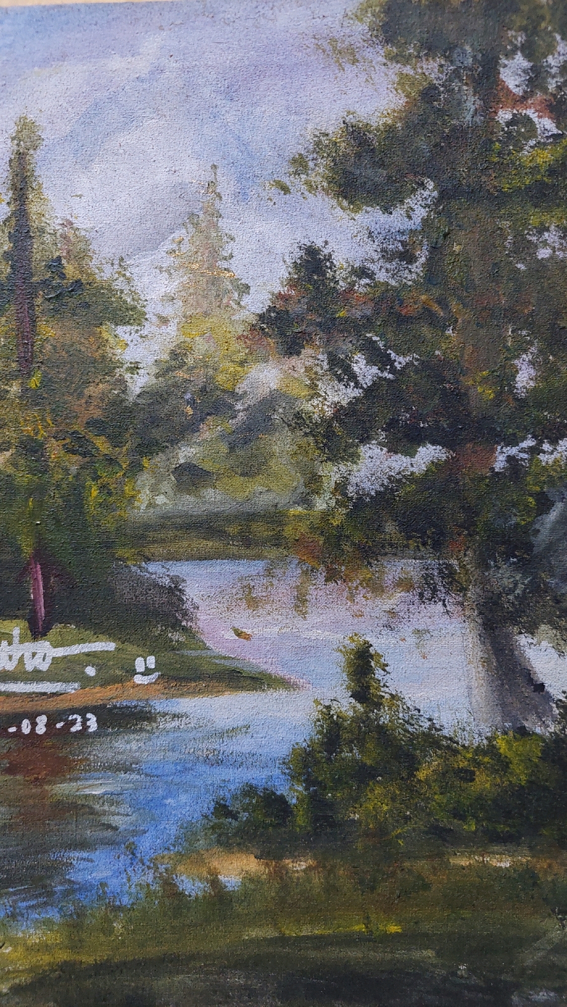 This is a detail of a painting that depicts a serene landscape with a body of water surrounded by trees. The water reflects the sky and the foliage. In the foreground, there is a white inscription that appears to be a signature or date. The inscription reads "who" followed by a smiley face symbol and then "-08-23". The painting has a textured appearance, suggesting it is an oil or acrylic painting on canvas. The overall impression is one of a tranquil natural setting. The painting does not contain any elements that would allow for identification of a specific location in Bojong Gede, Indonesia.