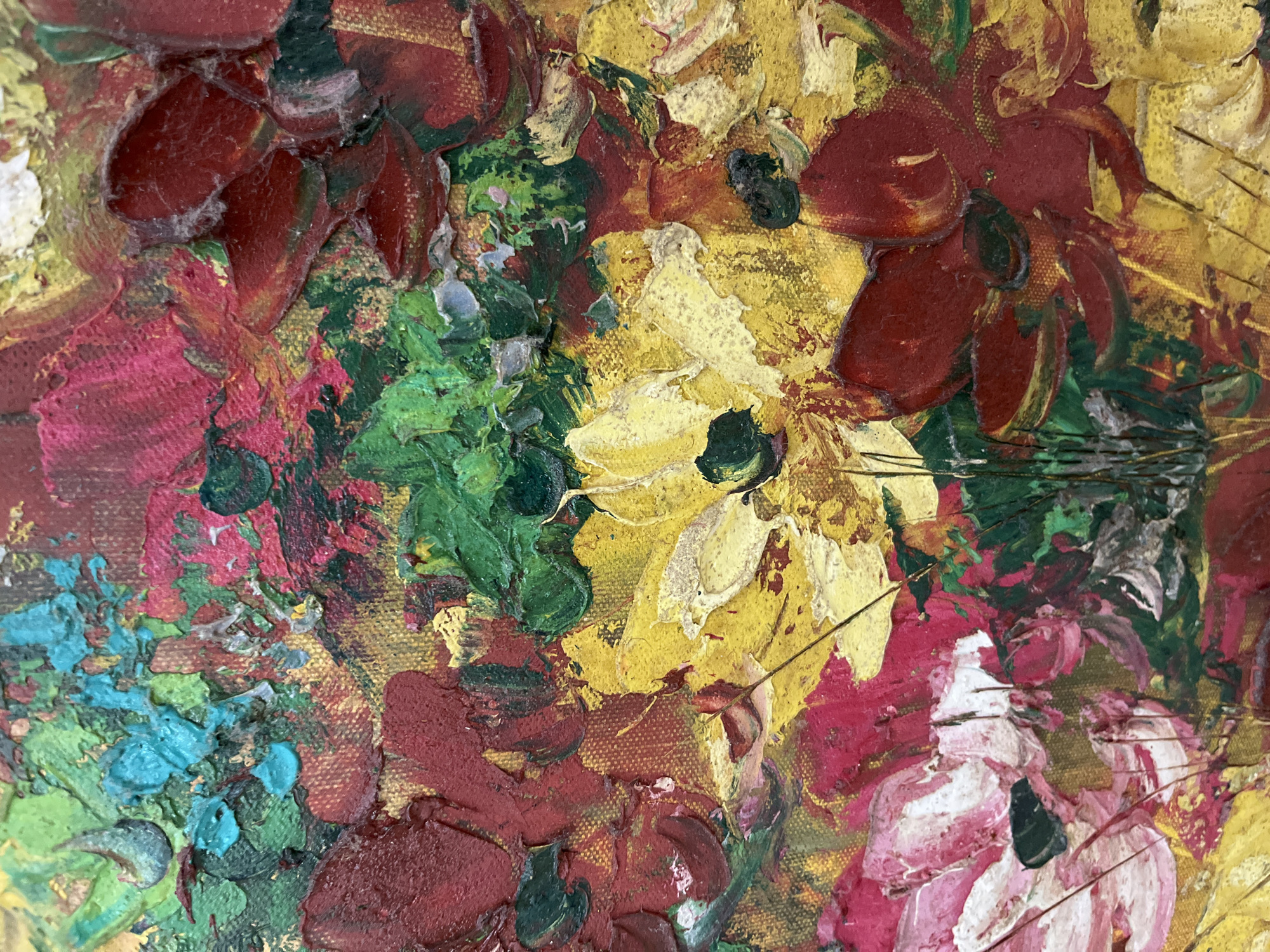 This is a close-up, highly textured oil painting of a floral arrangement. The paint is applied thickly, creating a three-dimensional impasto effect. Dominant colors include deep reds, vibrant yellows, lush greens, and touches of pink and turquoise. The flowers appear to be a mix of anemones, poppies, and other vibrant blossoms. The brushstrokes are visible and energetic, suggesting a dynamic and somewhat abstract representation of the flowers. The background is a textured canvas with hints of gold and earth tones. There are no people or identifiable elements of Kuta Selatan, Indonesia in this image; it is purely a depiction of flowers.
