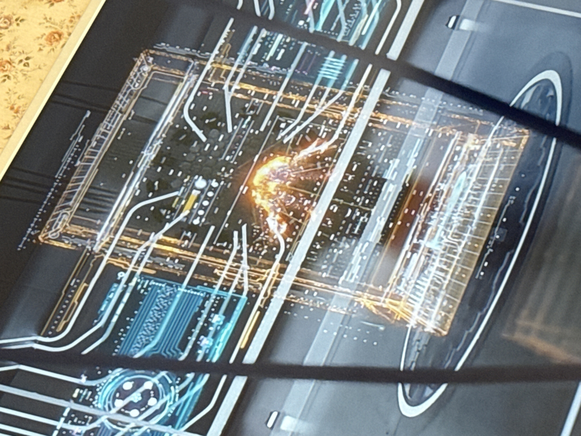 The image shows a computer screen displaying an abstract, schematic representation of a city plan. The city plan is rendered in a digital style, with glowing lines and grid-like structures overlaid on a dark background. There is a bright, concentrated area of orange light near the center of the schematic, possibly indicating a point of interest or a focal point in the city's infrastructure.
While the style of the representation is abstract, there are elements that could be interpreted as roadways, buildings, or other urban features. The image also includes what appears to be a stylized representation of a vehicle or a vehicle system integrated into the city plan.
The information needed to specify the location as the city of Mytishchi, Russia, is not visible in the image.