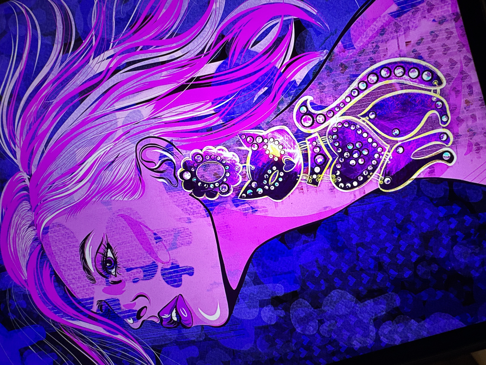 A digital illustration depicts a stylized portrait of a woman with vibrant pink hair, facing left in profile. Her face is rendered in shades of pink and purple, with dramatic eyeliner and full lips. She wears a large, ornate earring in her left ear, which transitions into a pendant shaped like a cat adorned with numerous sparkling jewels. The background is a deep blue with a textured pattern of small hearts and blurred circular shapes. The overall aesthetic is bold, graphic, and heavily stylized, with a strong emphasis on color and decorative elements. The image does not contain any identifiable elements of a city or location.