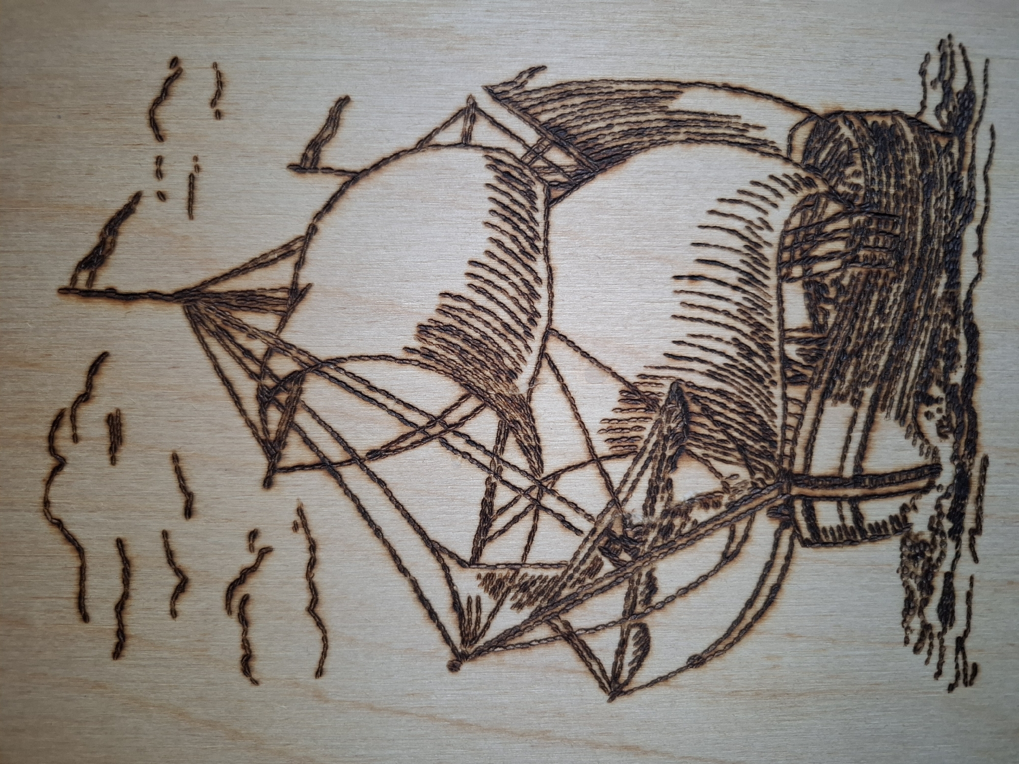 The image shows a wood burning artwork depicting a stylized sailing ship with prominent sails and rigging. The ship appears to be in the water, suggested by vertical lines resembling waves or ripples in the lower left corner. The background is plain, light-colored wood. The design is rendered with varying densities of burn marks to create tonal contrast and suggest depth. There is no information from the image indicating the city of Амзя, Russia.