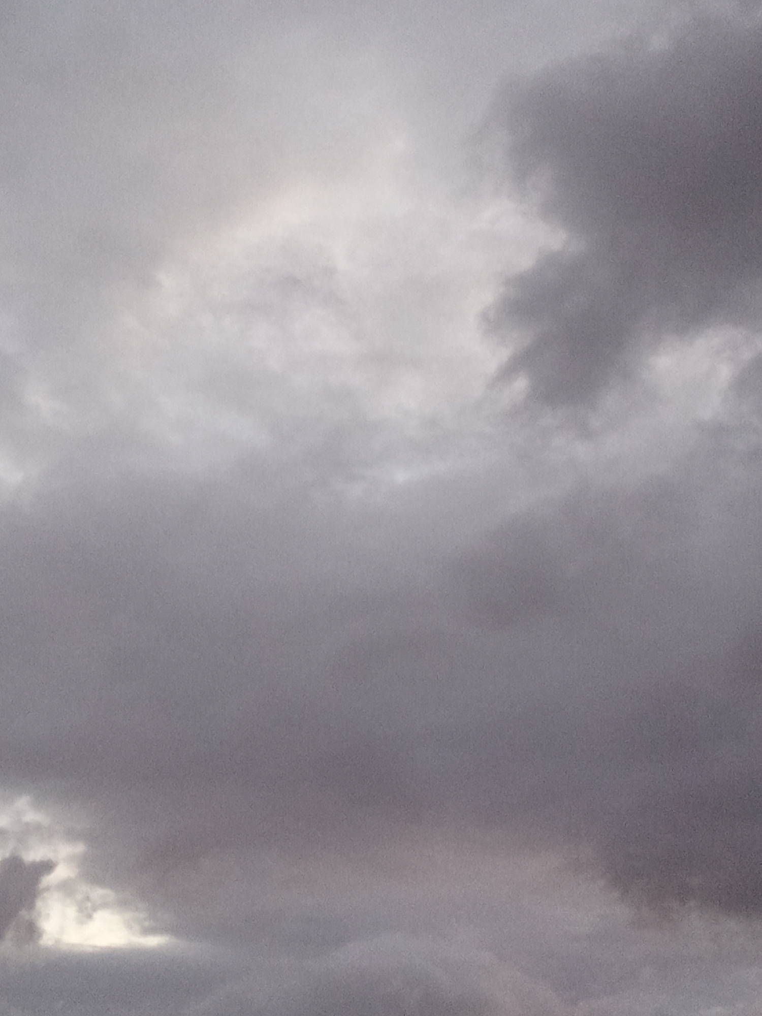 The image shows a gray and overcast sky, likely taken during daylight hours. The sky is filled with clouds of varying densities, with some areas appearing lighter and others darker. There is no evidence of the location as the city of Juan Griego, Venezuela, or of any human presence or activity. The scene is entirely focused on the atmospheric conditions.