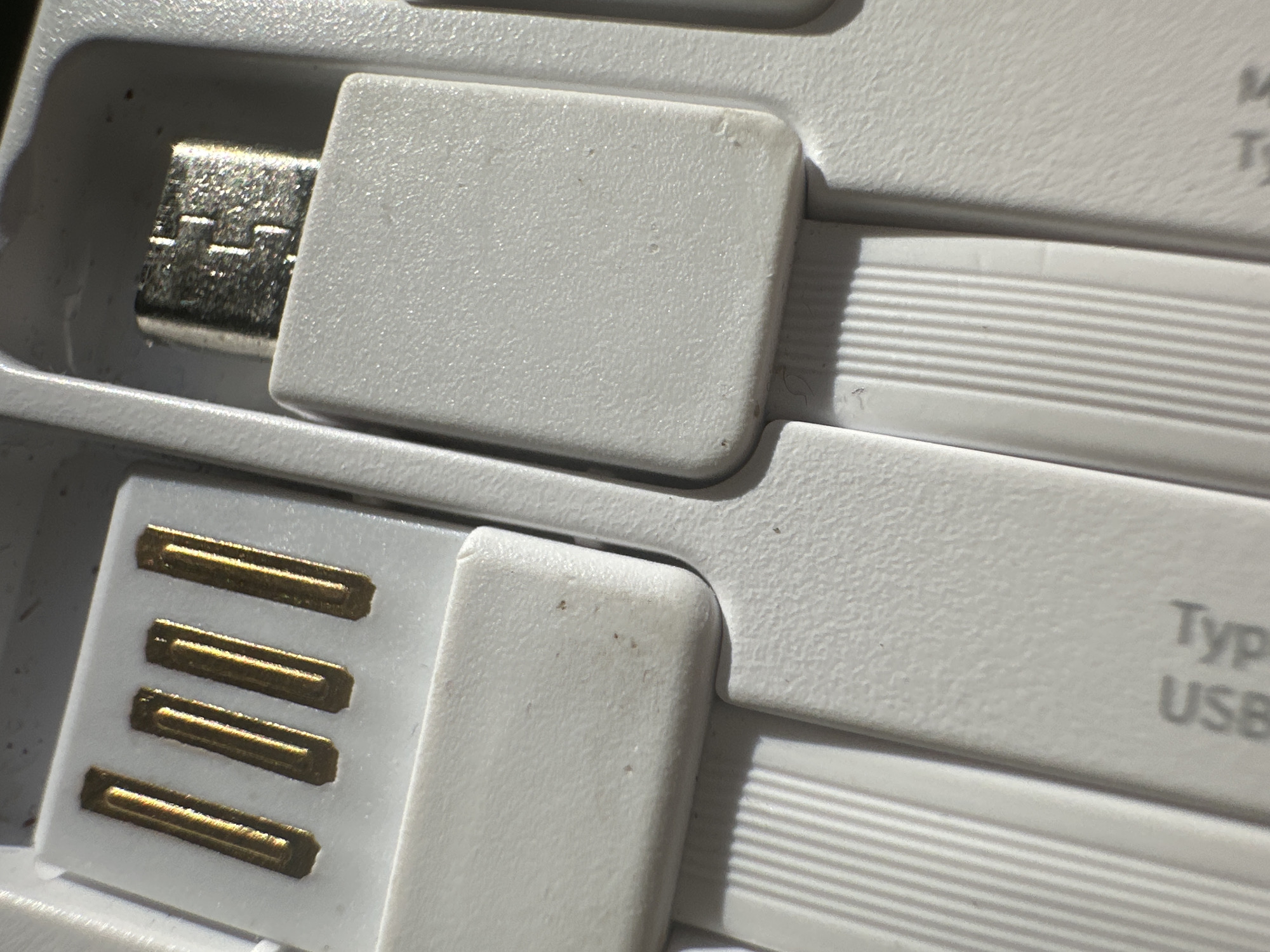A close-up image shows two white USB connectors. The top one is a micro-USB connector with a metallic head. The bottom one is a standard USB connector with four gold-colored contacts. The connectors are embedded in a white plastic casing with horizontal ridges. The text "Typ USB" is visible on the bottom connector's casing. The scene appears to be indoors with consistent lighting. There is no indication of this image being from Кузнечиха, Russia.