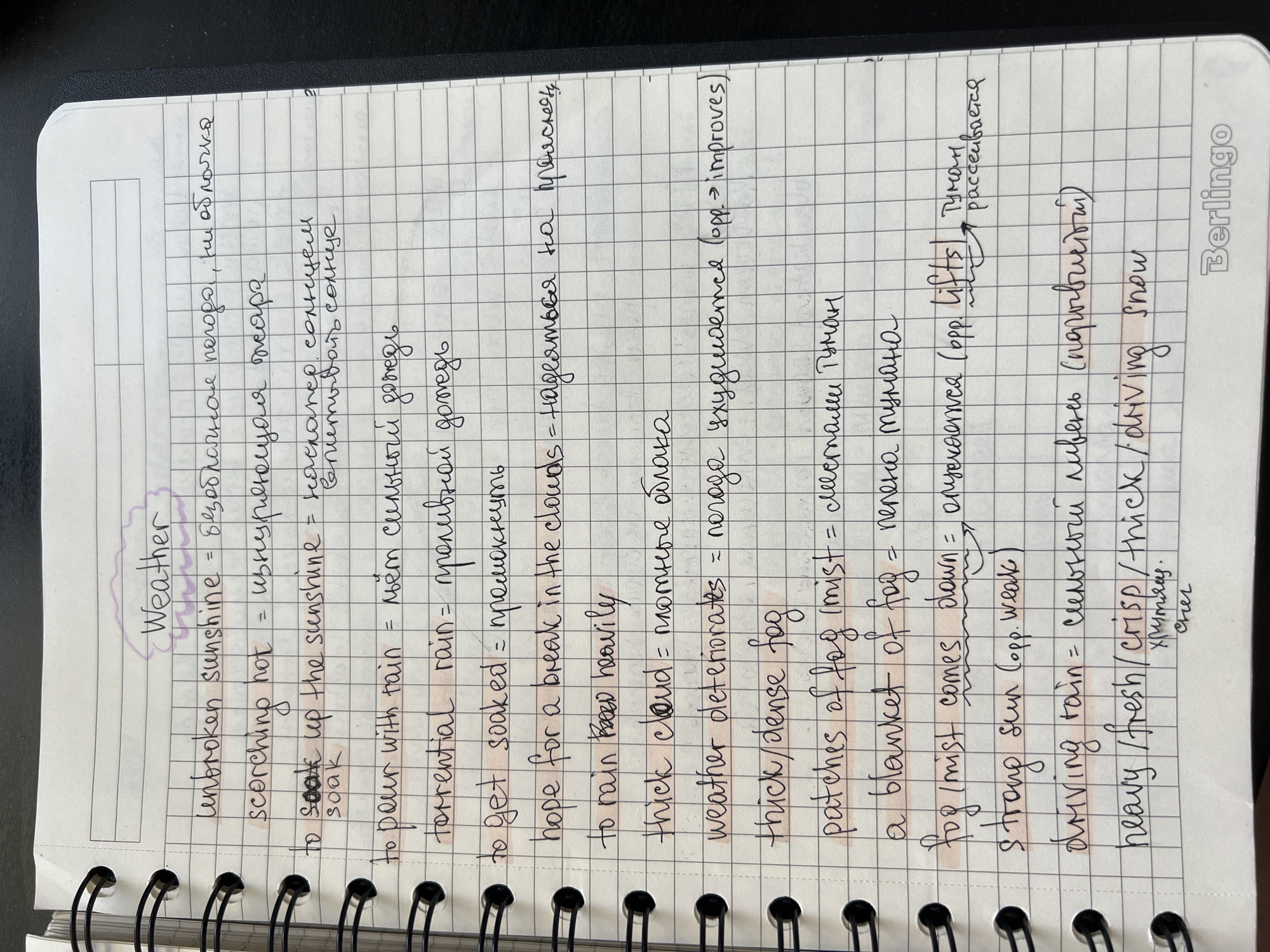 The image shows a close-up of a notebook page with handwritten notes about weather. The page is ruled with a grid pattern. The notes are in English with Russian translations. The handwriting is in black ink. Some words and phrases are highlighted with pink marker. The top of the page has "Weather" written inside a purple cloud shape. The bottom right corner of the page has the embossed logo "Berlingo". The notebook appears to be a standard spiral-bound notebook. The image does not provide any information about a specific location in Novosibirsk, Russia, or any details about people, actions, or interactions.