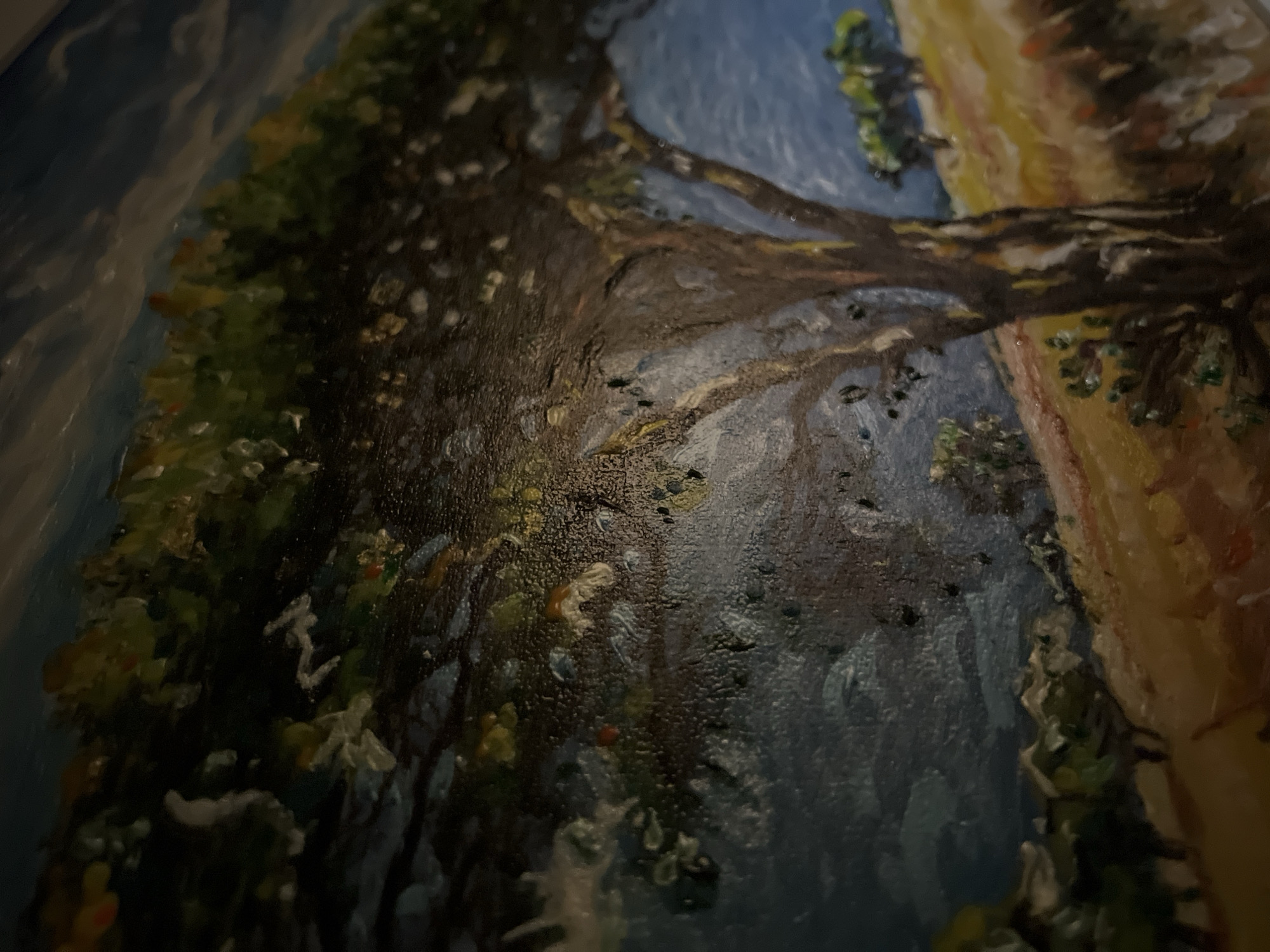 This is a close-up, angled, textured oil painting of a landscape. A large, dark tree with a textured brown trunk and dark green foliage dominates the foreground, leaning towards the right side of the frame. The background depicts a rolling, yellow and orange hill under a dark blue, cloudy sky. In the distance, on the hill, are smaller green trees. The paint application is thick and impasto, creating a highly tactile surface. There is no discernible location within the city of Minsk, Belarus, or any people or specific actions depicted.