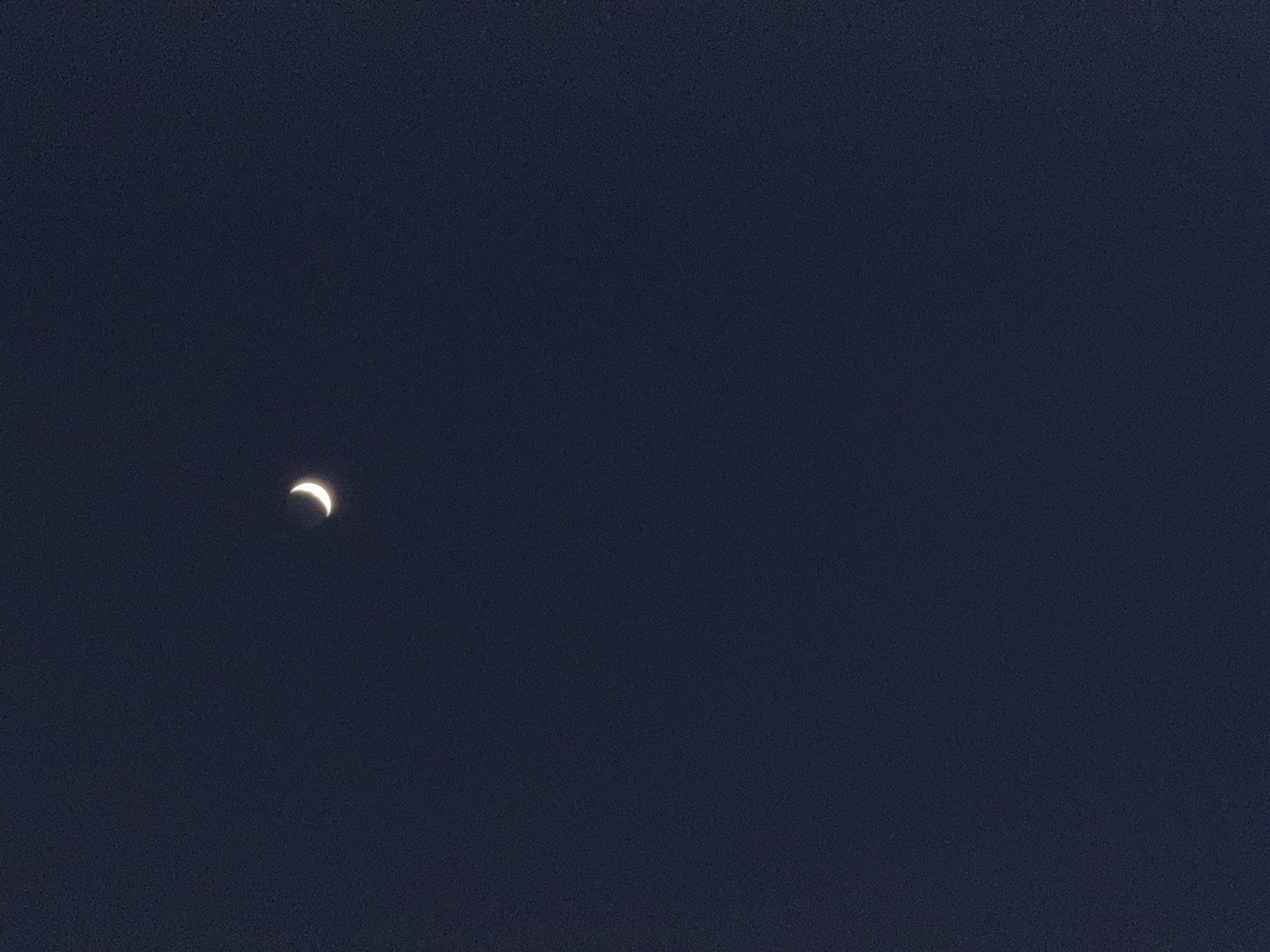 The image shows a crescent moon against a dark blue sky. There are no other objects or people visible in the image. The location in the city of Great Yarmouth, United Kingdom, cannot be determined from the image.