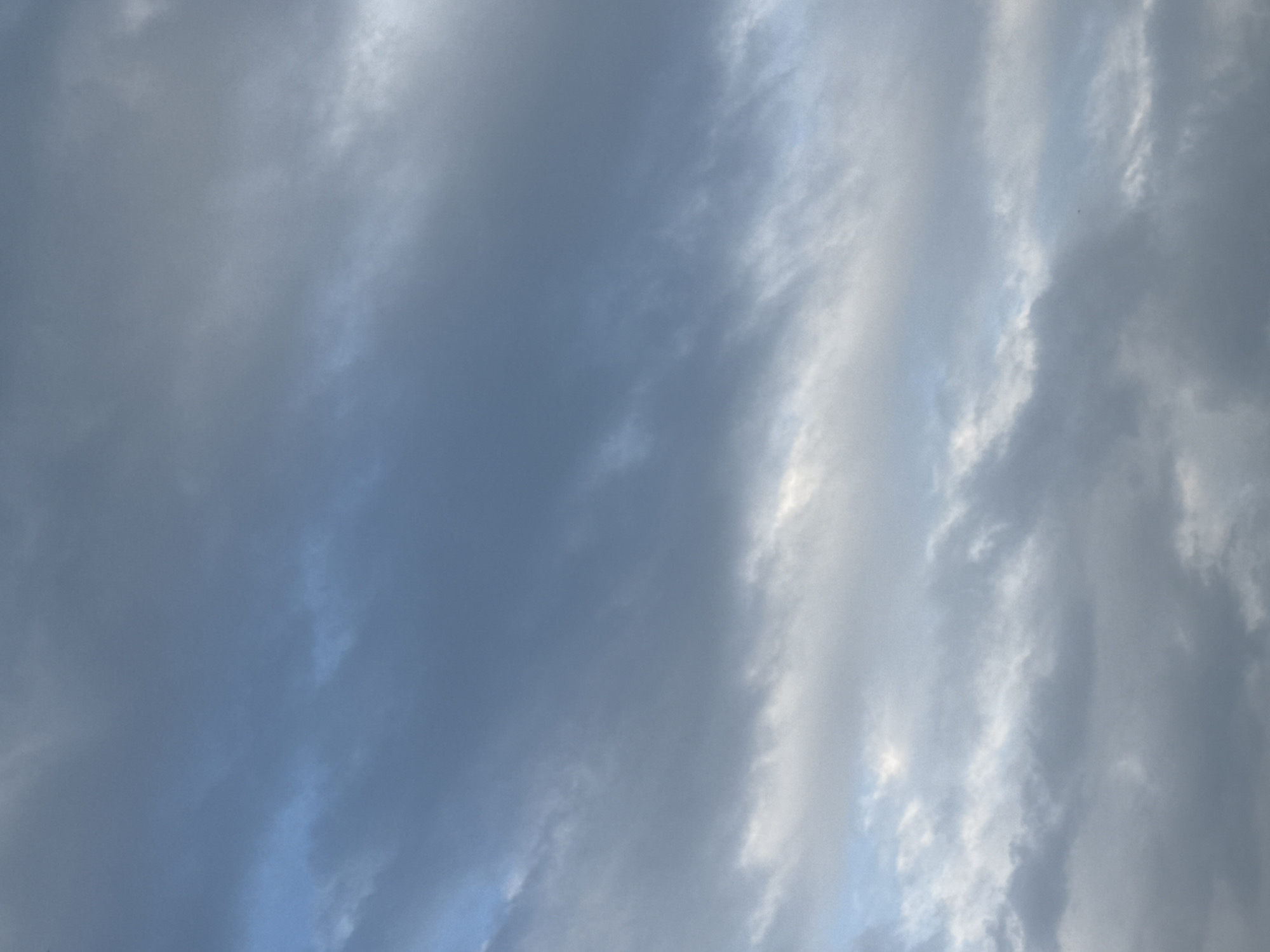 The image depicts a cloudy sky. The clouds are varied in shade, with some appearing dark and dense, while others are lighter and more wispy. There are hints of blue sky peeking through in some areas. The overall impression is that of an overcast or partially overcast day. No specific geographical markers are visible within the image to indicate the location in Yessentuki, Russia. There are no people, subjects, or objects depicted, nor any discernible actions or interactions. The environment is solely composed of the sky and clouds.