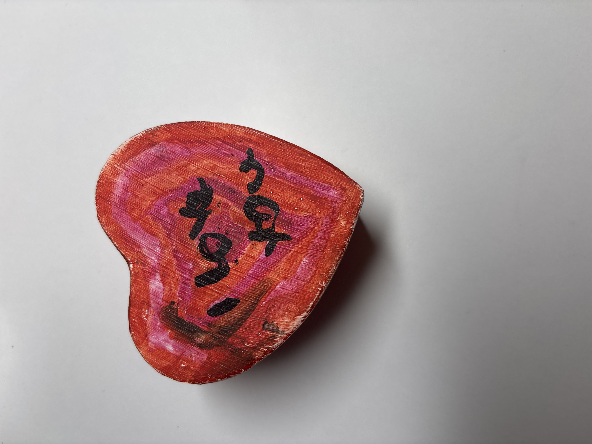The image shows a heart-shaped object with the words "I love you" written on it in black marker. The object is red and pink, with visible wood grain. It is lying on a white surface. The image does not provide any information about the location in Velbert, Germany.