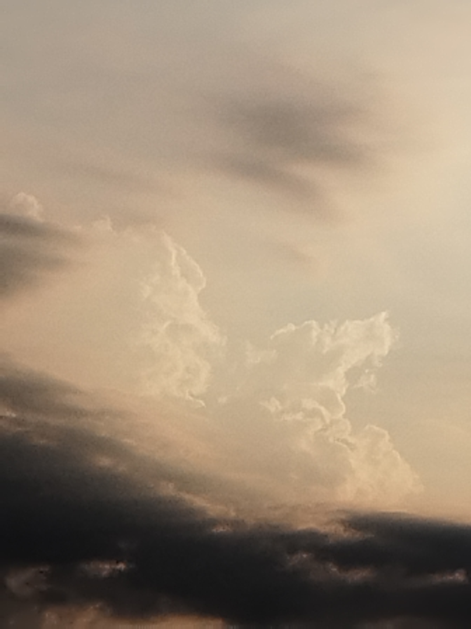 The image shows a sky filled with clouds, with the sun setting or rising, casting a warm, golden light. The clouds are a mix of dark and light shades, with some appearing fluffy and others more wispy. The overall impression is one of a dramatic and beautiful sky. There are no people, subjects, objects, or actions visible in the image. The scene is set outdoors, in the sky. It is not possible to determine the location within the city of Vidra, Romania from the provided image.