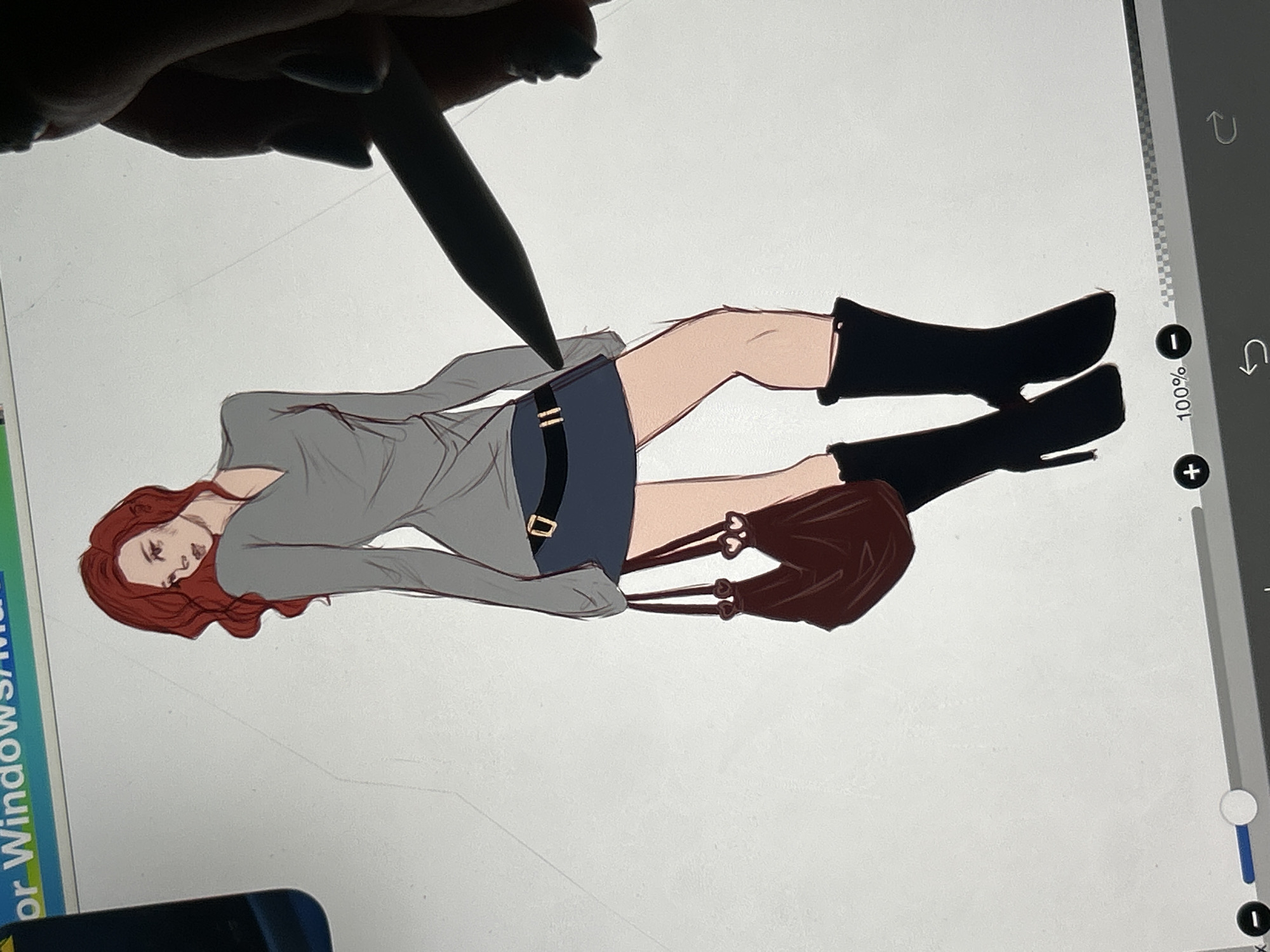 The image depicts a digital drawing in progress of a woman with red hair, wearing a grey V-neck top, a dark blue skirt with a black belt, and black heeled boots. She is carrying a dark red handbag with heart-shaped charms. The drawing is on a white digital canvas, and a stylus is visible being used to create the artwork. A portion of a user interface with sliders and buttons is visible at the bottom of the image. There is no indication of the city of Cupra Marittima, Italy, or any recognizable urban environment.