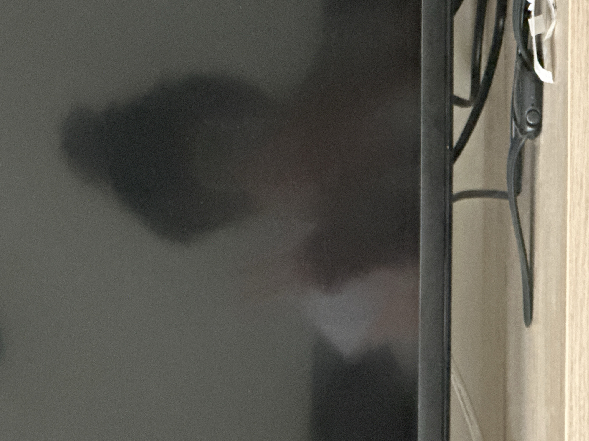 A partial view of a dark television screen reflecting a room, positioned against a light-colored wooden surface with black cables. The location and city of Sofia, Bulgaria, cannot be determined from the given image.
