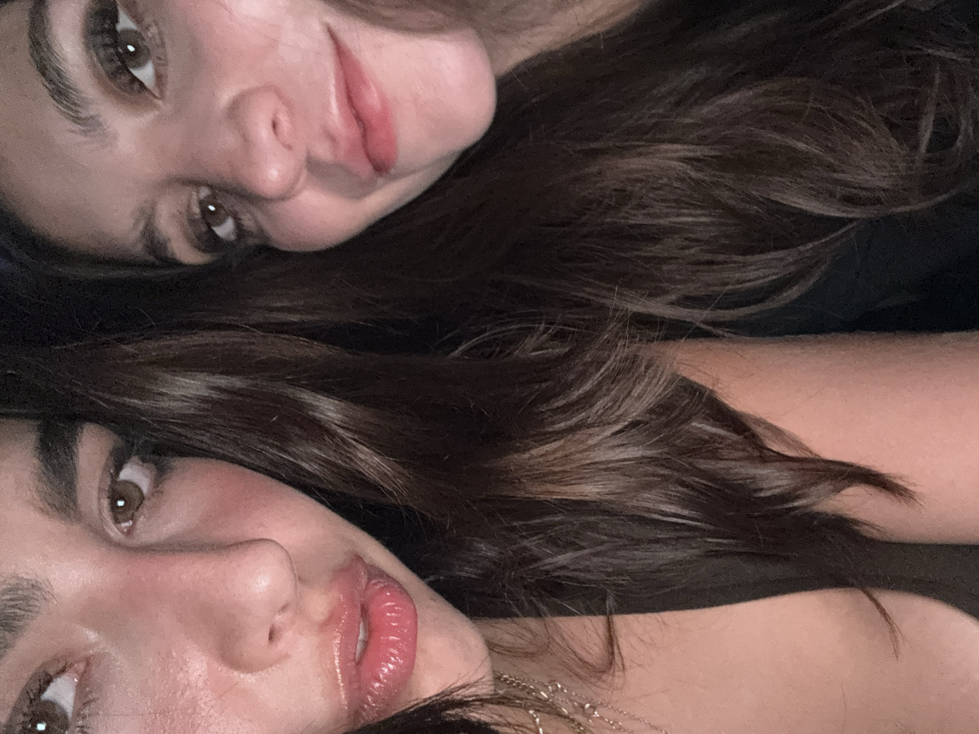 Two people with brown hair and light skin are lying close to each other. Their faces are visible, showing brown eyes and lips. The background appears dark, possibly indicating an indoor setting. There is no indication of the location being Mexico City.