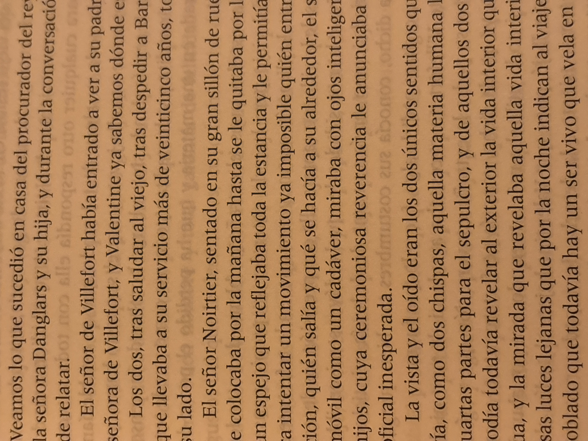 The image shows a page of a book written in Spanish. The text appears to be a narrative, describing characters and their interactions. The story mentions a scene at the procurator's house, featuring characters named Danglars, Villefort, Valentine, and Noirtier. Noirtier is described as sitting in a large armchair, observing his surroundings with intelligent eyes. The text also notes that Noirtier's only remaining senses are sight and hearing. The image does not depict any location in Santa Clara Ocoyucan, Mexico.