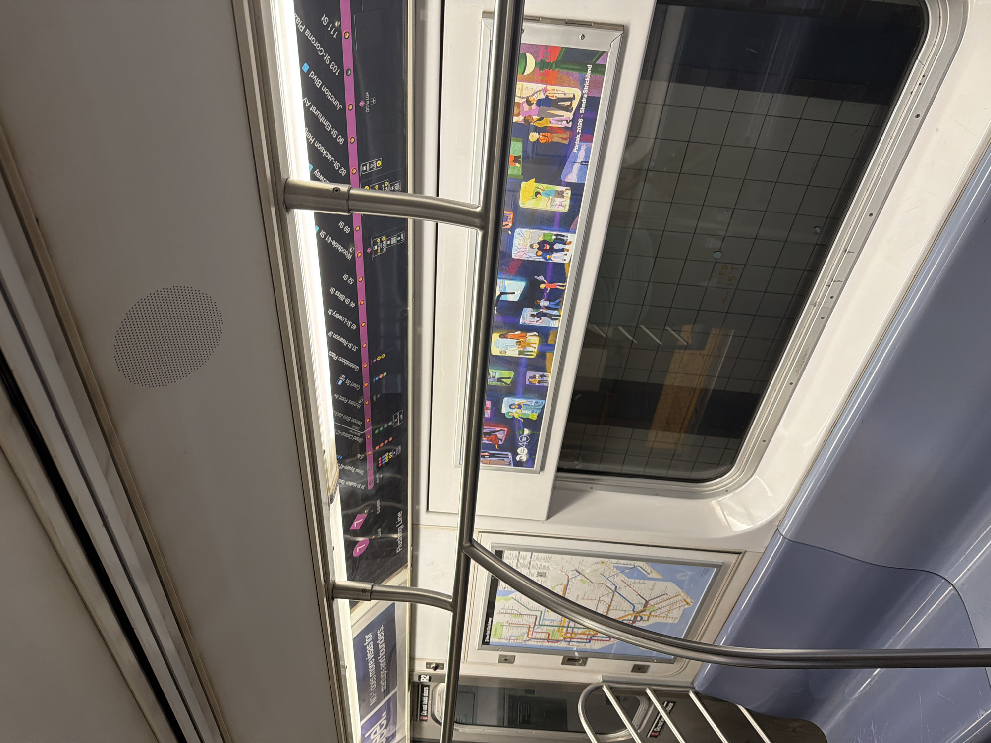 The image shows the interior of a New York City subway car. In the upper left is the train line diagram, indicating stops along the 7 line from 111 St to 34 St-Hudson Yards. The next frame contains artwork titled "Portals, 2026 - Shadra Strickland". Below is a map of New York City. A handrail is visible in the foreground. The window is in the upper right. Additional signage about visas and not holding the doors can be seen. The scene is located in New York City, United States of America.