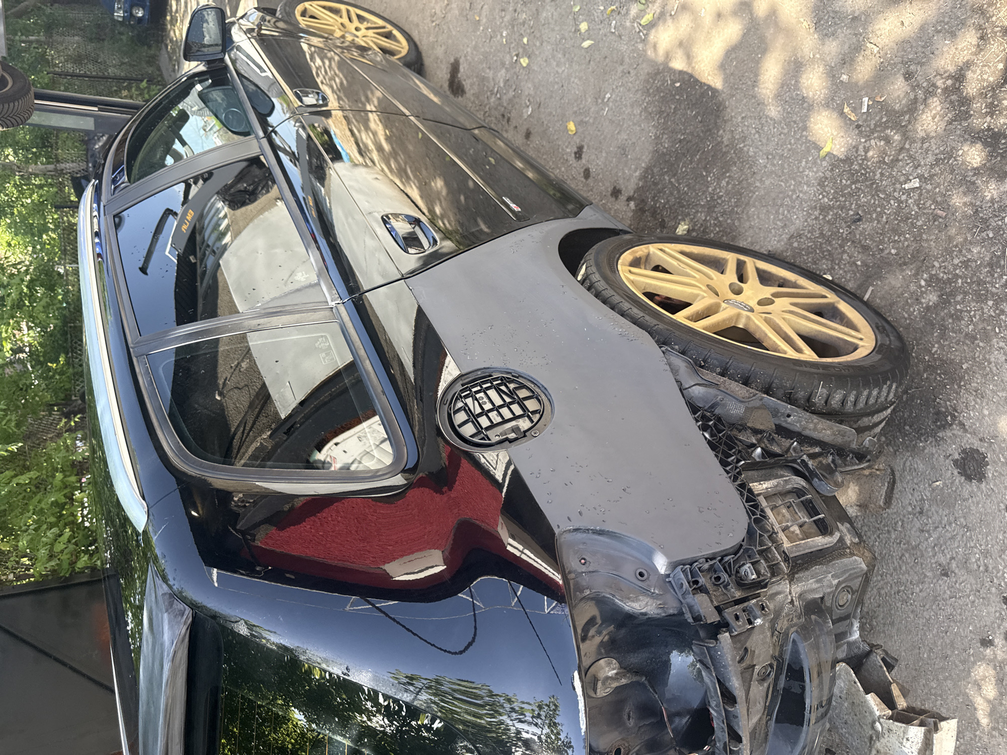 The image shows a black car with significant damage to its rear end, specifically to the bumper and surrounding areas, including the wheel well. The car has gold-colored rims. The setting appears to be outdoors on a paved surface. Based on the limited visual information, there is no clear evidence to support identifying the specific city as Sofia, Bulgaria.