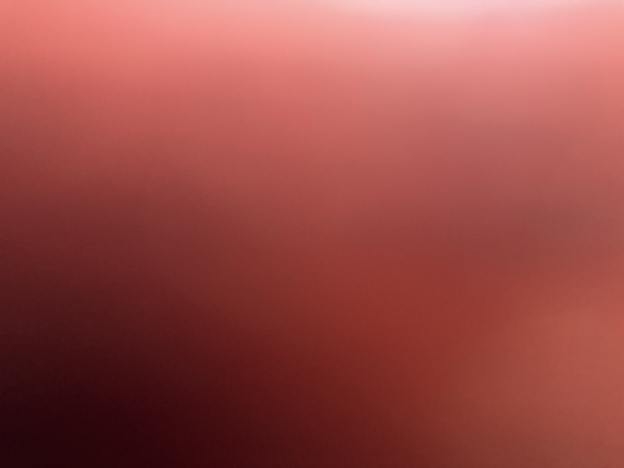 This is an abstract, out-of-focus image featuring a gradient of deep red to soft pink hues. There are no discernible objects, people, or environmental features present. The image is a pure color field with a luminous quality, suggesting it may be a digitally generated background or a photographic effect. Therefore, it is not possible to provide any details about the city of Belgrade, Serbia, as there is no visual information to support such a connection.