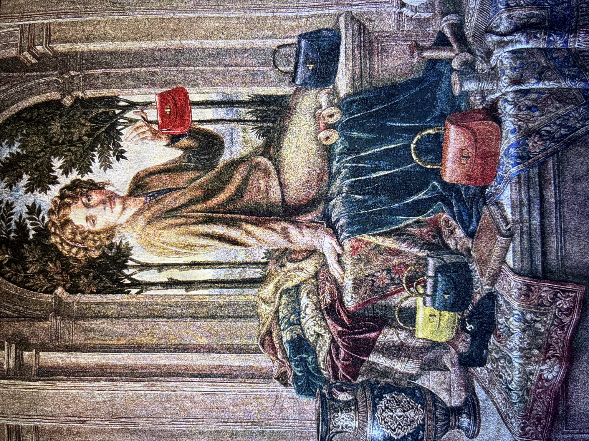 The media file displays a richly textured tapestry or woven artwork, depicting a scene with a blend of classical aesthetics and modern objects. The central figure is a woman with fair skin and curly hair, possibly adorned with a laurel wreath or braids. She wears a flowing, light-colored tunic or robe and gazes forward with a serene, slightly contemplative expression.
She is holding up a small, vibrant red, rectangular handbag in her right hand, seemingly presenting or admiring it. Surrounding her, and draped over what appears to be a stone balustrade or ornate furniture, are several other structured handbags. These include a dark blue one with gold hardware, another rounded red one with a gold handle, and in the lower right, a dark blue and a yellow handbag, both with short handles.
The setting features classical architectural elements, such as stone columns, arches, and a balustrade, which frame the scene. Lush green foliage, possibly trees or bushes, is visible through an archway behind the woman, suggesting an outdoor or semi-outdoor garden or courtyard. The foreground and mid-ground are adorned with opulent, intricately patterned textiles, resembling rugs or throws, in shades of blue, red, gold, and cream. A large, ornate dark blue vase with decorative patterns is also visible in the lower right corner.
The lighting is soft and consistent, creating an idealized, timeless atmosphere without specific cues for time of day or weather. There is no discernible text visible in the image. The scene conveys a sense of quiet elegance and a juxtaposition of ancient and contemporary elements.