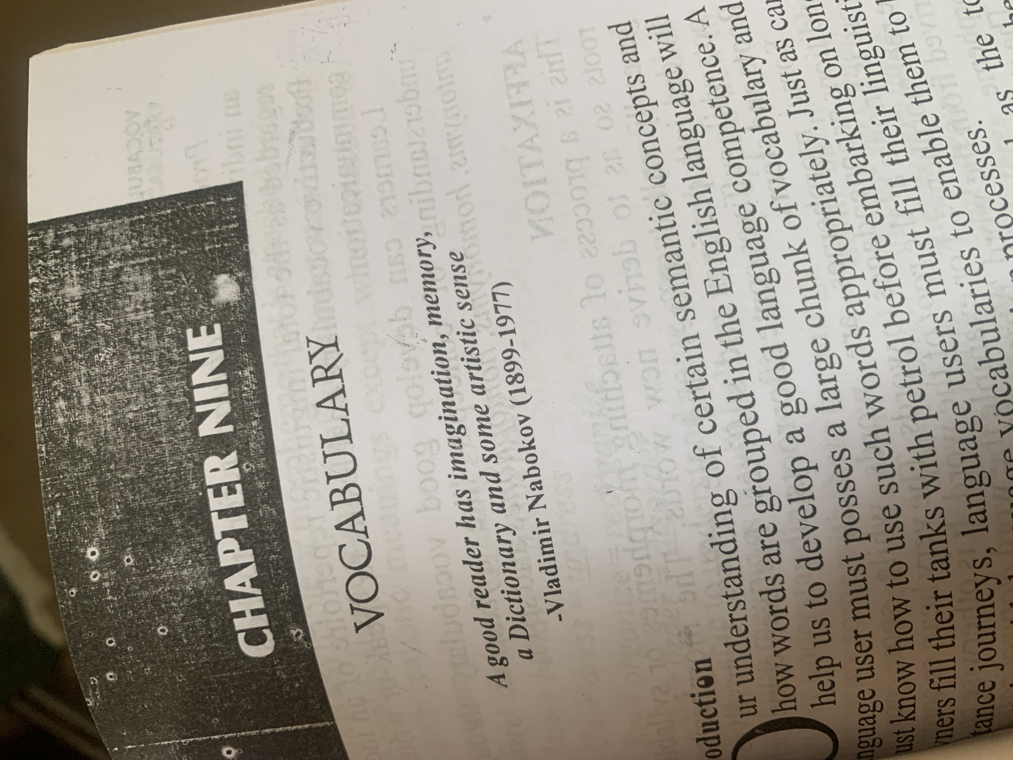 The image shows an open book with text printed on its pages. The visible text includes "CHAPTER NINE" and "VOCABULARY". Below this, there is a quote attributed to "Vladimir Nabokov (1899-1977)". The text then transitions into paragraphs discussing language, understanding, and vocabulary. There are no discernible elements in the image that can be linked to Jauro Yinu, Nigeria, or any specific city. The scene is a close-up of a book and provides no information about the surrounding environment or any people.