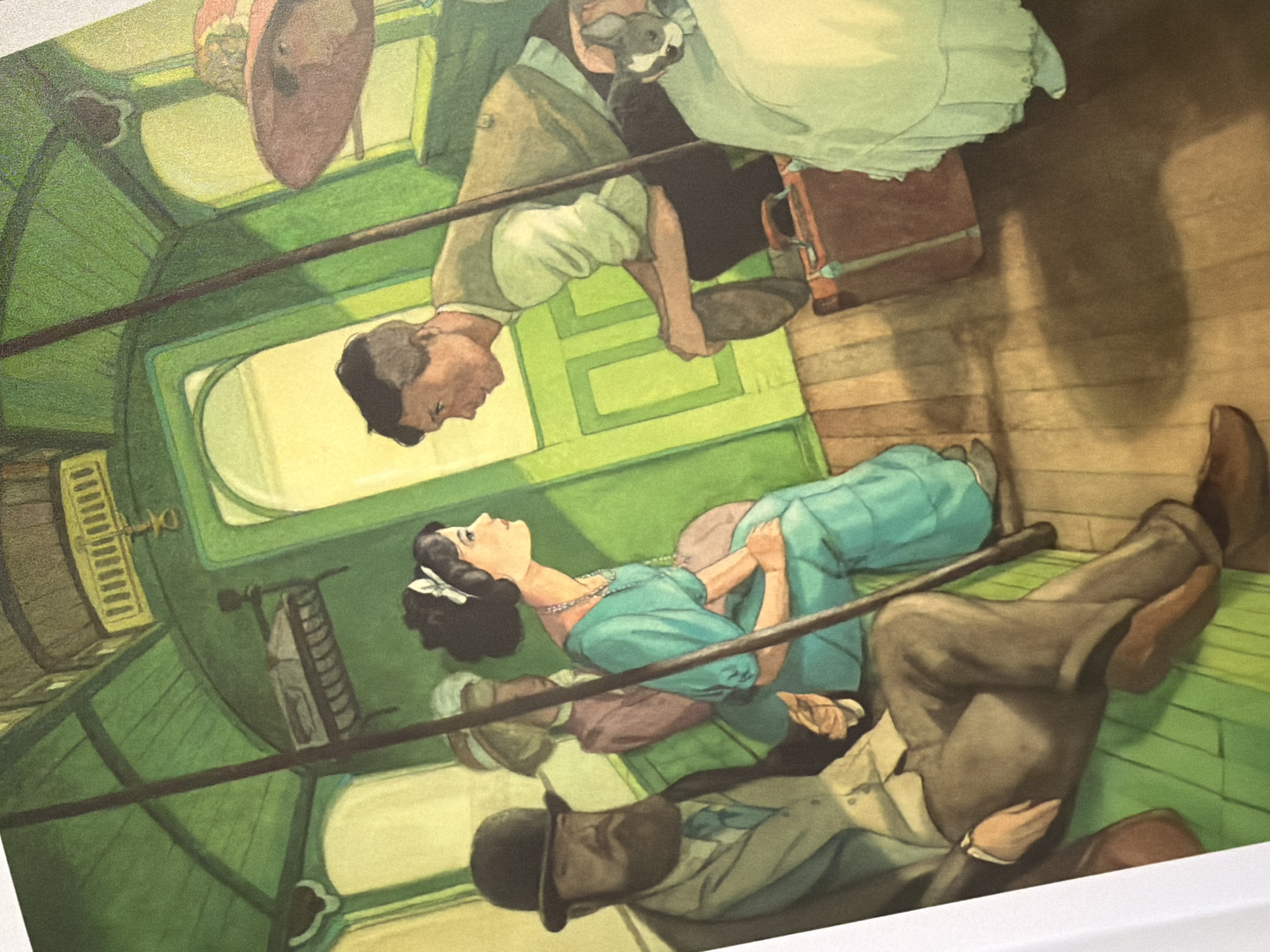 The image depicts an interior scene within a green, wooden vehicle, possibly a tram or train car, suggesting an urban setting. The environment is characterized by green painted walls and ceiling, with visible wooden floorboards. Sunlight streams in, creating shadows.
In the foreground left, a man with a beard, wearing a dark hat and a light-colored suit with a blue tie, is seated with his legs crossed. He is looking forward.
To his right and slightly behind, a woman with dark hair tied with a white ribbon and wearing a turquoise dress sits facing forward. She is looking towards the man on the right.
Behind the woman in turquoise, another woman in a hat and a pink jacket is partially visible, also seated.
On the right side of the vehicle, a man with short dark hair, wearing a light-colored shirt and a vest, is leaning forward, appearing to be in conversation with the woman in turquoise. He is holding a hat in his lap. Next to him, a small white and gray dog with a blue ribbon around its neck is visible, peeking out from behind a white draped object. A brown suitcase rests on the floor near the man.
The style of dress and the vehicle interior suggest a historical period, likely late 19th or early 20th century. The scene does not contain any specific visual cues that would place it in Pazardzhik, Bulgaria.