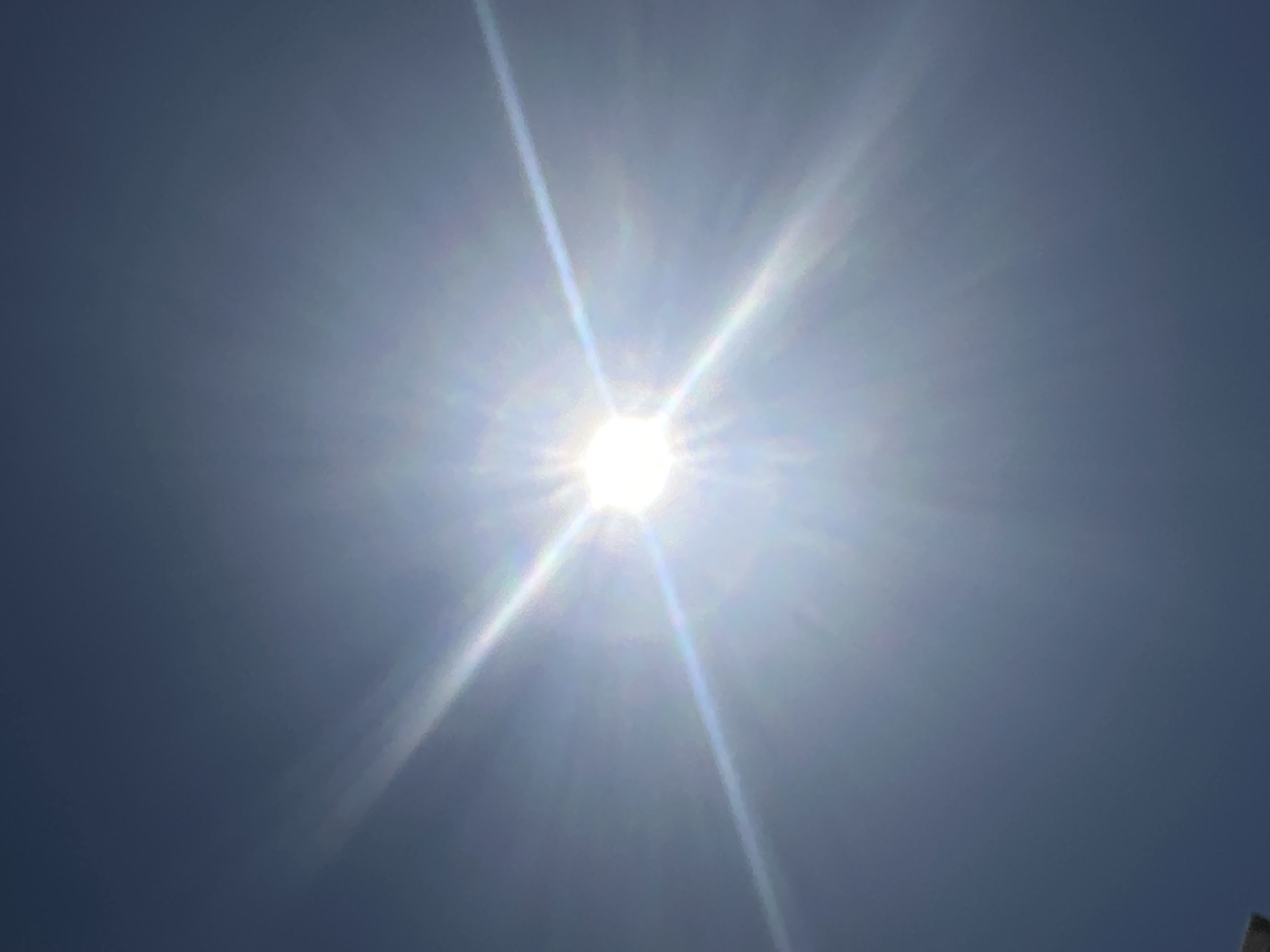 The image shows a bright sun in a pale blue sky. No people or objects are clearly visible other than the sun and the sky. The exact location in Sant Feliu de Guíxols, Spain, cannot be determined from this image.