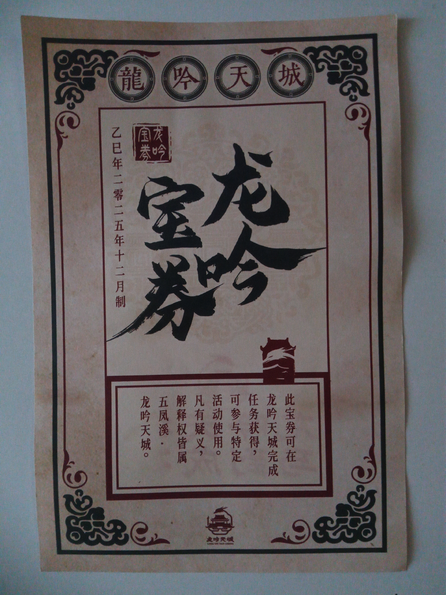 The image is a close-up shot of an antique-style certificate or ticket, predominantly in Chinese. The background appears to be aged paper, possibly parchment, with a light brown hue and some visible texture.
The top of the certificate features three circular emblems, each containing a Chinese character. From left to right, these characters appear to be "龍" (lóng, dragon), "吟" (yín, chant/bellow), and "城" (chéng, city). Below these emblems, in the upper left quadrant, is a rectangular stamp with red Chinese characters, which likely represents a seal. To the right of this stamp, large, bold, black calligraphic characters dominate the central area, reading "龍吟券" (lóng yín quàn), meaning "Dragon Chant Ticket" or "Dragon Bellows Ticket."
To the left of the "龍吟券" characters, there is a vertical column of smaller Chinese characters. These appear to be a date, "乙巳年二零一五年十二月制" (yǐ sì nián èr líng yī wǔ nián shí èr yuè zhì), which translates to "Made in December 2015 of the Yi Si Year."
The bottom section of the certificate contains a red-bordered box with several lines of smaller Chinese text. The first line, "此宝券可在" (cǐ bǎo quàn kě zài), means "This precious ticket can be." The second line reads, "龙吟天城完成" (lóng yín tiān chéng wán chéng), possibly indicating "Dragon Chant Celestial City completion." Below this, smaller text lists conditions or benefits: "任务获得," (rènwù huòdé, "tasks obtained"), "可参与特定" (kě cānyù tèdìng, "can participate in specific"), "活动使用。" (huódòng shǐyòng, "activity usage."). Further to the left, within the red box, are the characters "凡有疑义," (fán yǒu yíyì, "if there are any doubts"), and "五凤溪·" (wǔ fèng xī, "Five Phoenix Stream·"). The final line reads, "龙吟天城。" (lóng yín tiān chéng, "Dragon Chant Celestial City.").
At the very bottom center of the certificate, there is a small, stylized graphic that resembles a building or pagoda, also in red. Beneath this graphic, in very small print, is the text "龍吟天城" and "LONG YIN TIAN CHENG."
The certificate is framed by decorative elements, particularly at the corners, featuring swirling, oriental-inspired designs in black and red.
There is no indication in the image or the visual elements that this certificate is located in the city of Usman, Russia. The content is exclusively in Chinese and appears to be related to a Chinese context or cultural event. The image depicts an object, not a scene with people in a specific geographical location.