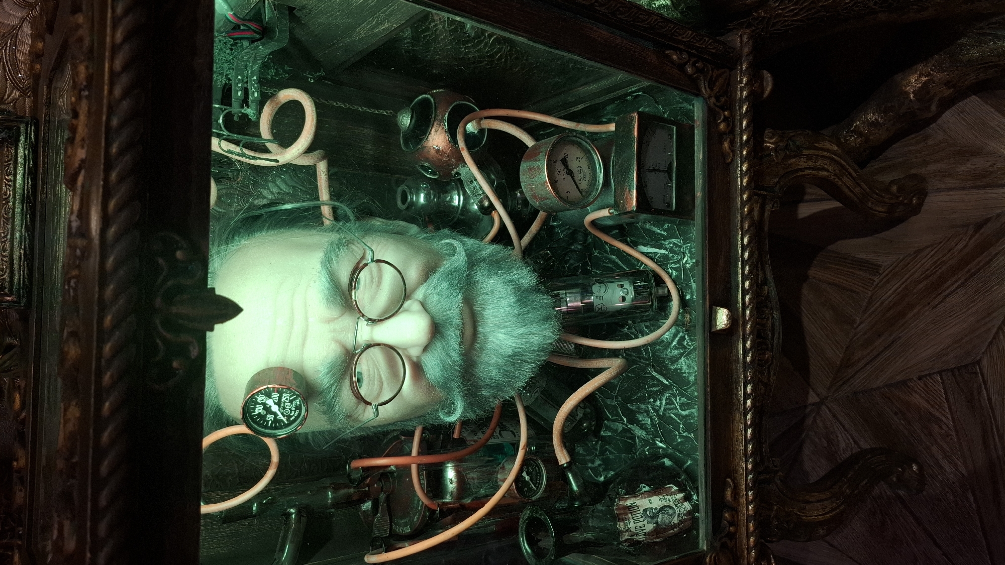 In the city of Unknown, Unknown, a close-up, high-angle shot captures a surreal, steampunk-themed display within a dimly lit room. The central subject is a lifelike, disembodied head of an elderly Caucasian male, positioned in a glass enclosure. The head features a balding pate, round eyeglasses, a prominent mustache, and a full beard. Greenish light permeates the scene, casting an eerie glow.
The head is adorned with various mechanical and scientific apparatus. A small, circular gauge with a needle is attached to the forehead, displaying readings. Orange tubes, reminiscent of medical or scientific tubing, connect to the head and snake around the enclosure, linking to other devices. Among these devices are glass vials and bottles, one labeled "LOVE POTION." Various metallic and glass components, including a vacuum tube, are visible, suggesting a complex, possibly alchemical or experimental setup.
The enclosure itself appears to be part of a larger, ornate piece of furniture. The top of the enclosure is framed by dark, intricately carved wood, featuring rope-like molding and decorative elements. Below the enclosure, the image shows the scrolled and carved legs of a wooden table or cabinet, with a textured wooden floor visible beneath. The overall impression is one of a fantastical laboratory or a macabre collection, imbued with a strong steampunk aesthetic.