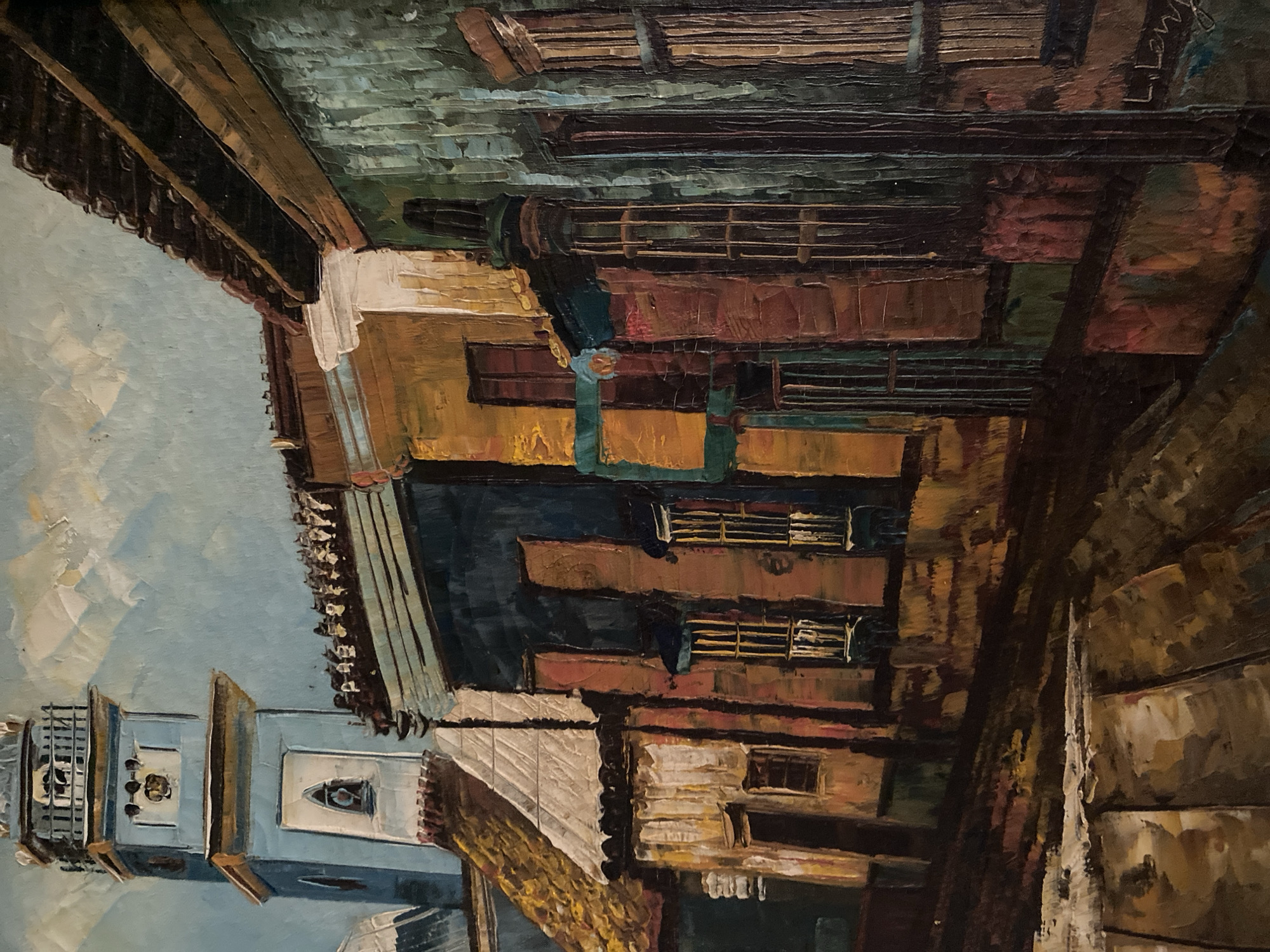 The image is a close-up oil painting of a street scene, likely in Tinaquillo, Venezuela. The painting is rendered in a somewhat expressionistic style.
A blue and white clock tower stands at the lower left. A building with visible windows and details of the construction is prominent. Other buildings, with doors and windows, are adjacent. The street itself is only implied by the perspective. The sky is partly visible. The perspective is slightly tilted/unconventional, looking upwards towards the buildings and sky.