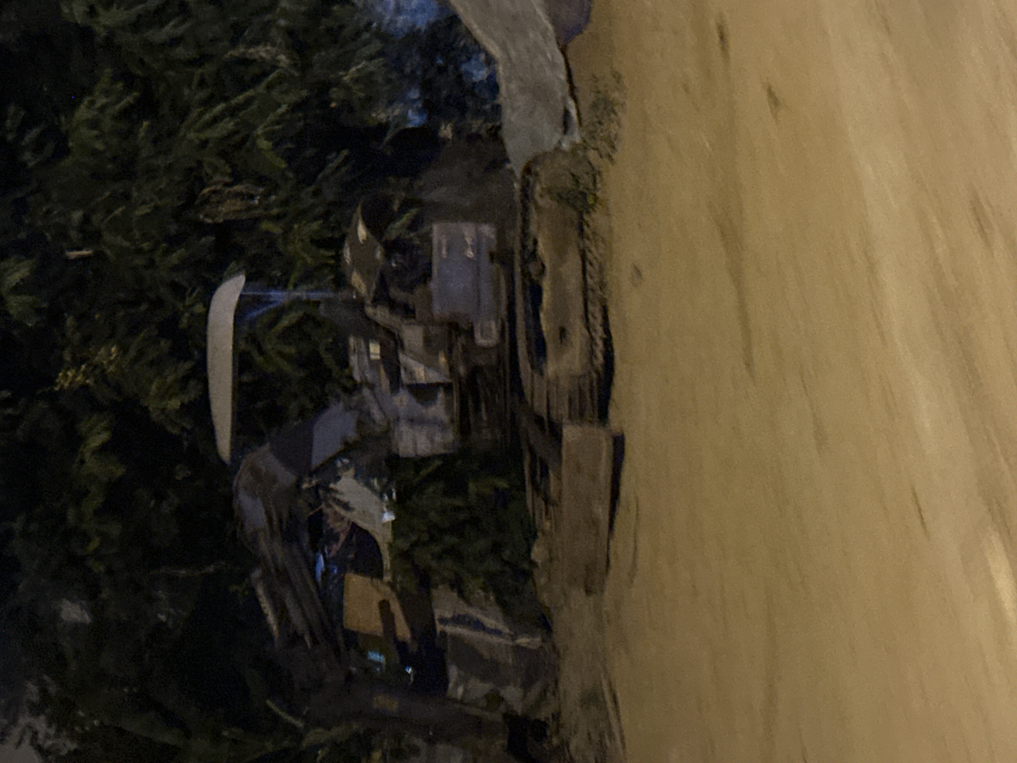 A daytime scene depicting a construction site in Bac Nha Trang Ward, Vietnam. A truck or other large construction vehicle is parked next to a road. A pile of dirt or debris is next to the vehicle. Dense vegetation or trees are adjacent to the construction area.